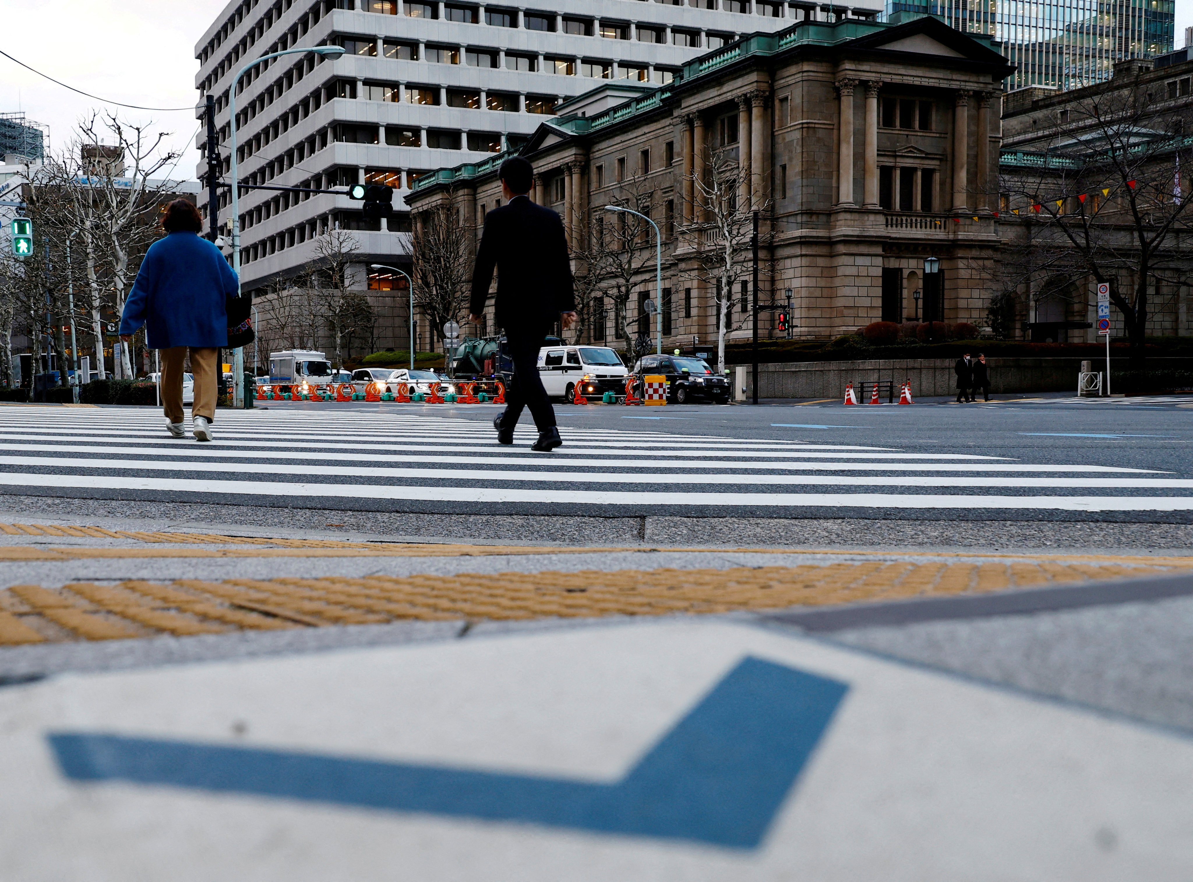 People walk in front of the Bank of Japan building in Tokyo. The rate hike will also increase Japan’s bill for servicing the national debt, which at around 260 per cent of national output is one of the world’s highest. Photo: Reuters