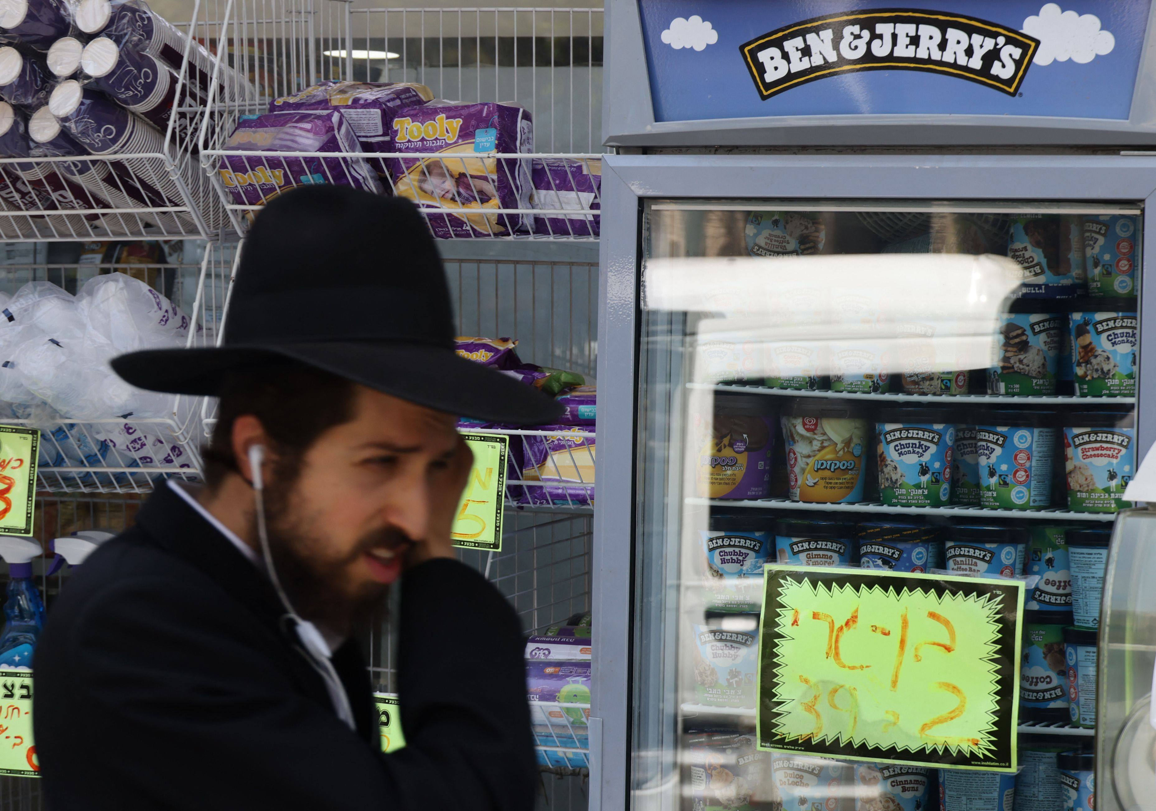 An Ultra Orthodox Jewish man walks by Ben & Jerry’s ice cream in Jerusalem. Ben & Jerry’s owner Unilever will spin off its ice cream arm, and cut 7,500 jobs globally. Photo: AFP