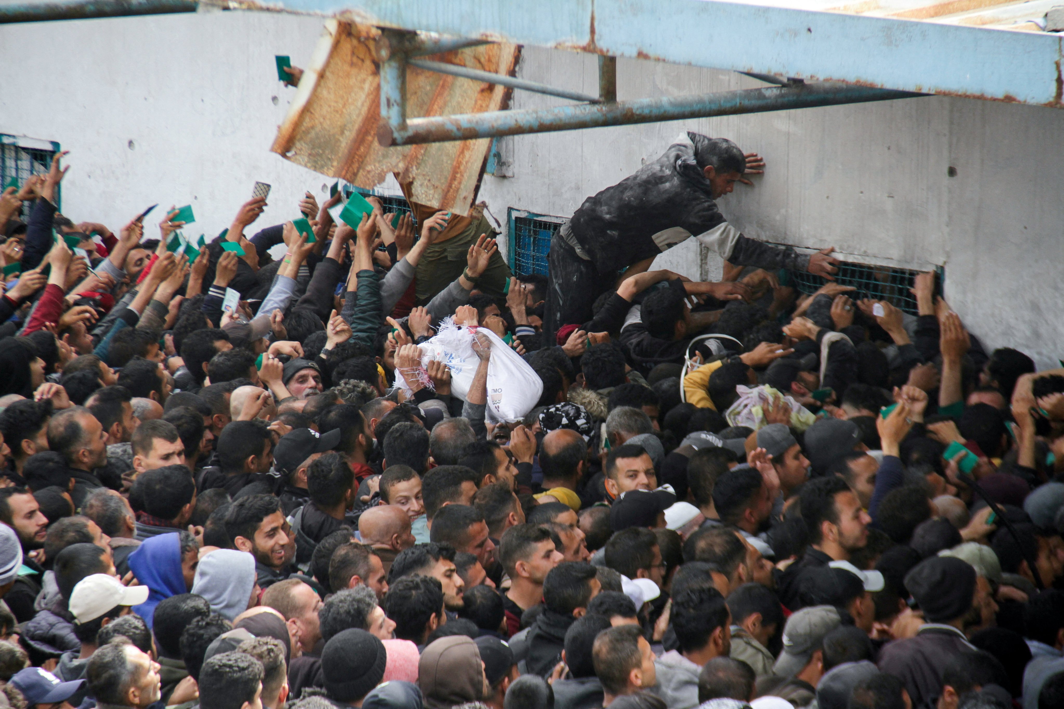 Palestinians gather to receive aid outside a UNRWA warehouse as Gazans face crisis levels of hunger. Photo: Reuters
