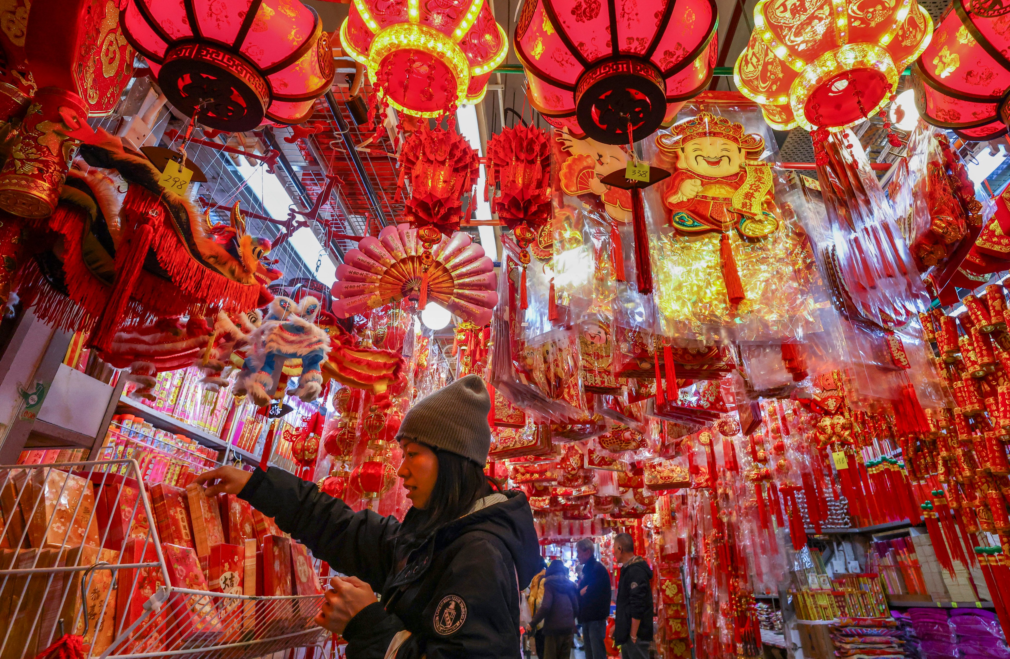 A shopper selects lai see - the red packets traditionally given out over the Lunar New Year holiday - amid a sea of festive ornaments at Tai Kiu Market in Yuen Long on January 28. Photo: Dickson Lee