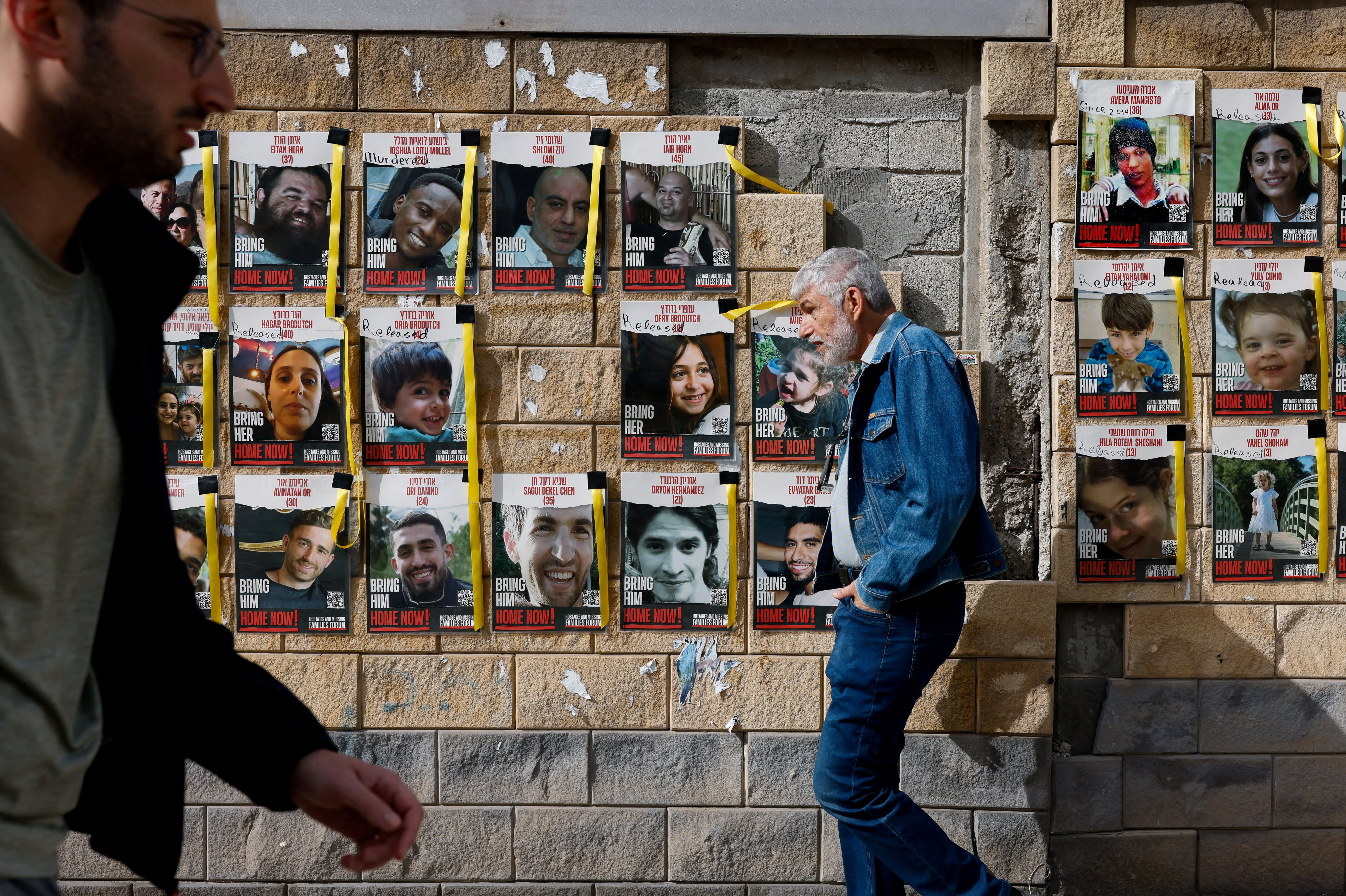 People walk past placards with photos of hostages kidnapped in the deadly October 7 attack on Israel by Hamas from Gaza, in Tel Aviv, Israel, on March 17. Photo: Reuters