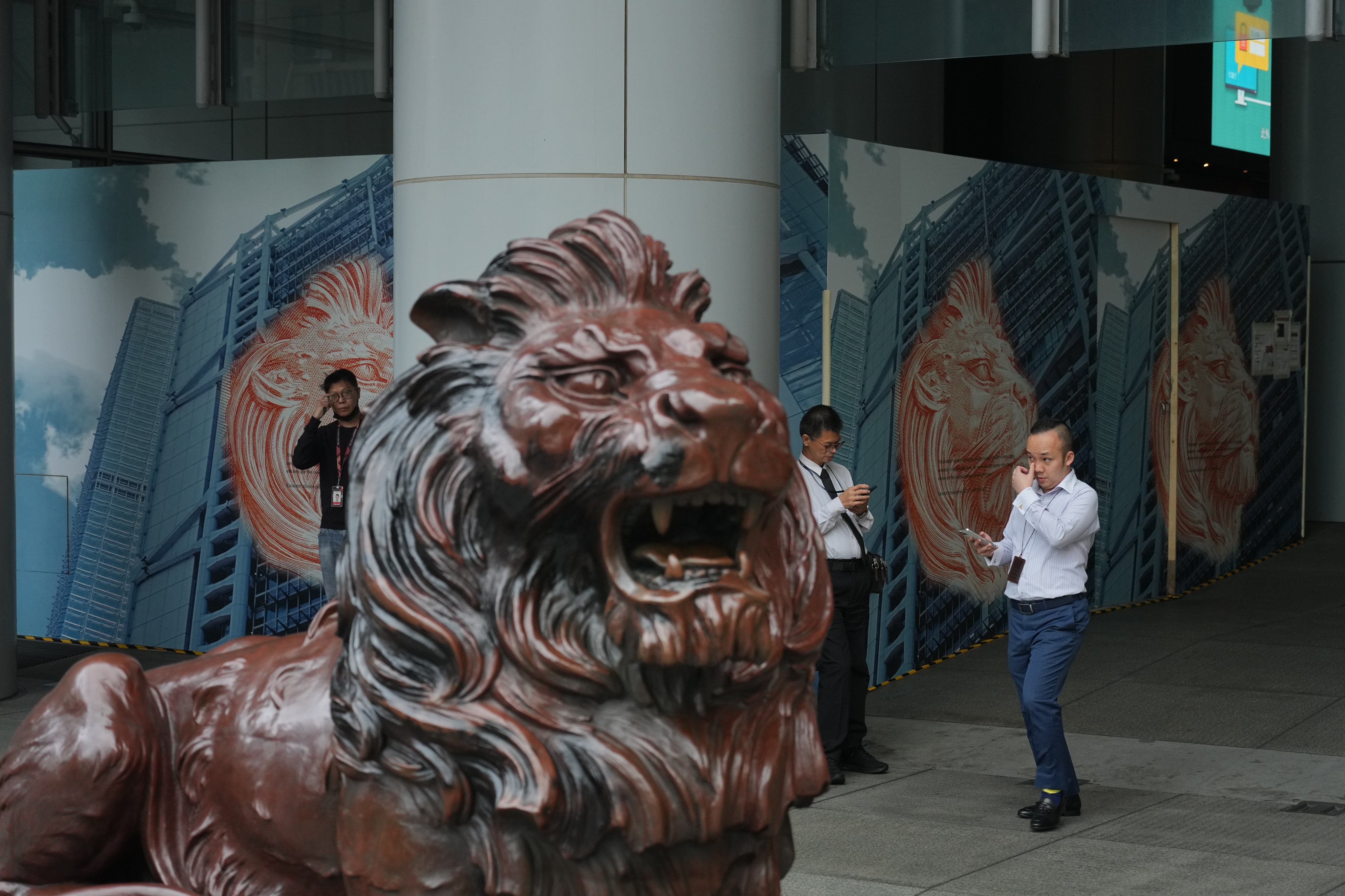 People walk past a lion sculpture outside HSBC’s headquarters building in Central, Hong Kong. Photo: Eugene Lee