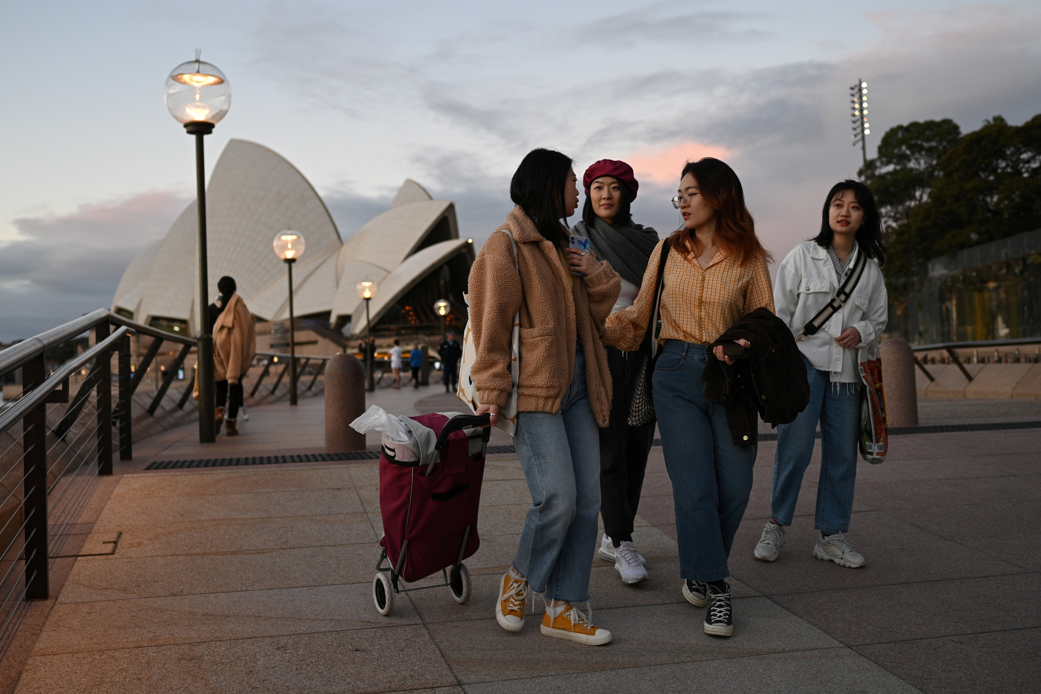 Students from China walk along the waterfront by the Sydney Opera House in Australia. Photo: Reuters