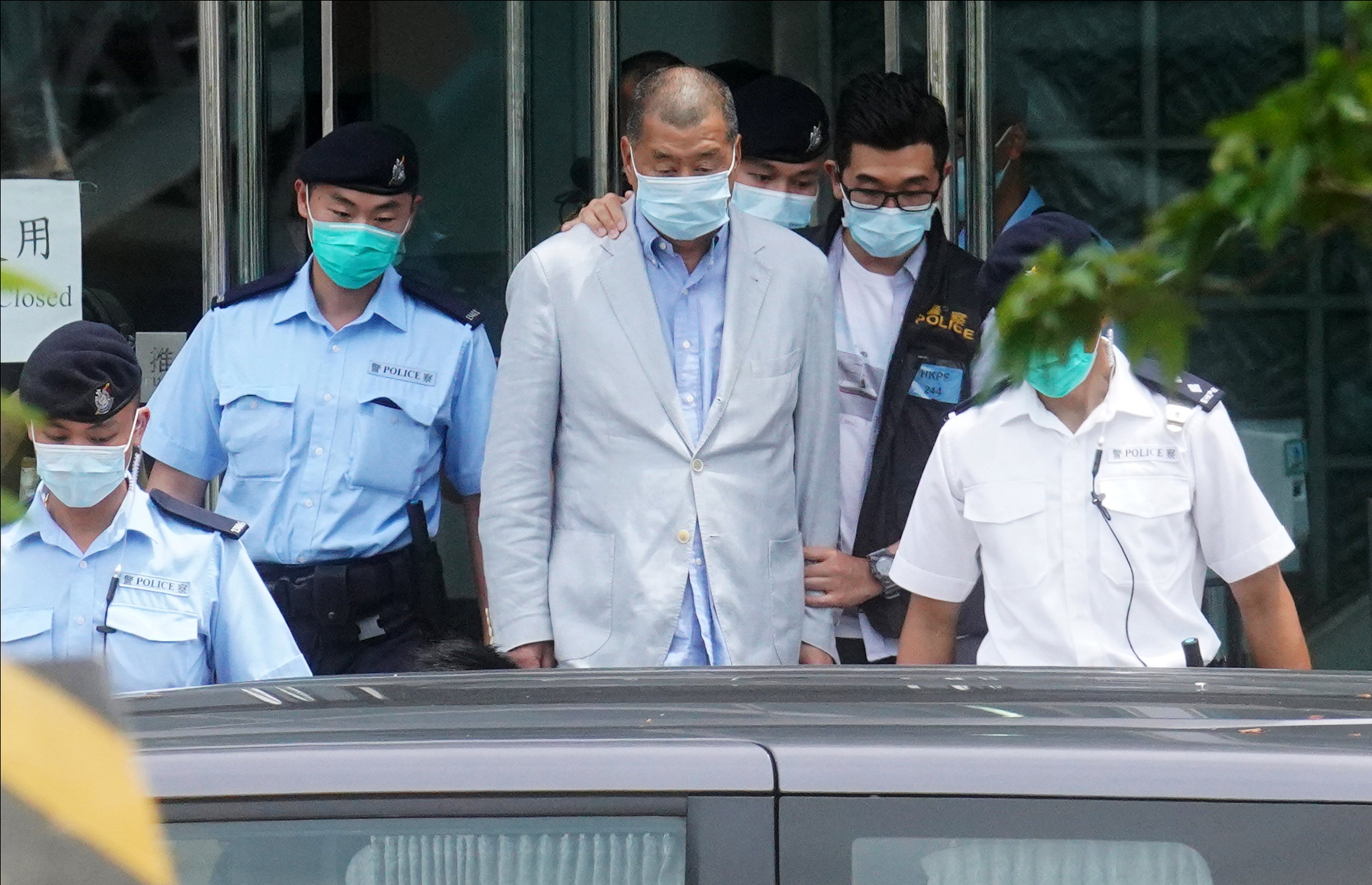 Jimmy Lai is escorted by police after a raid on his Apple Daily headquarters in August 2020. Photo: Winson Wong