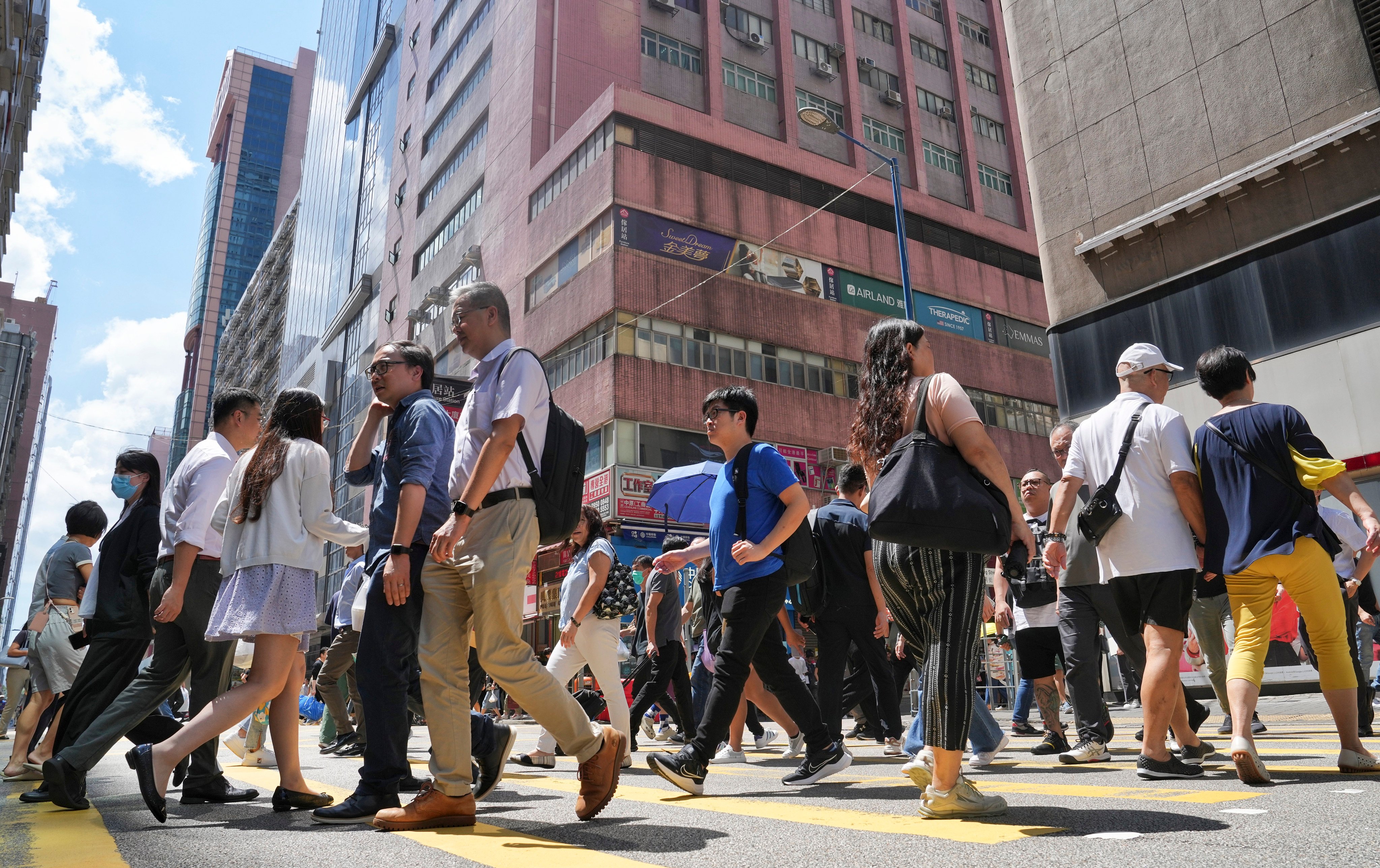 People cross a street in Hong Kong’s Kwun Tong commercial district on September 19, 2023. Photo: Elson Li