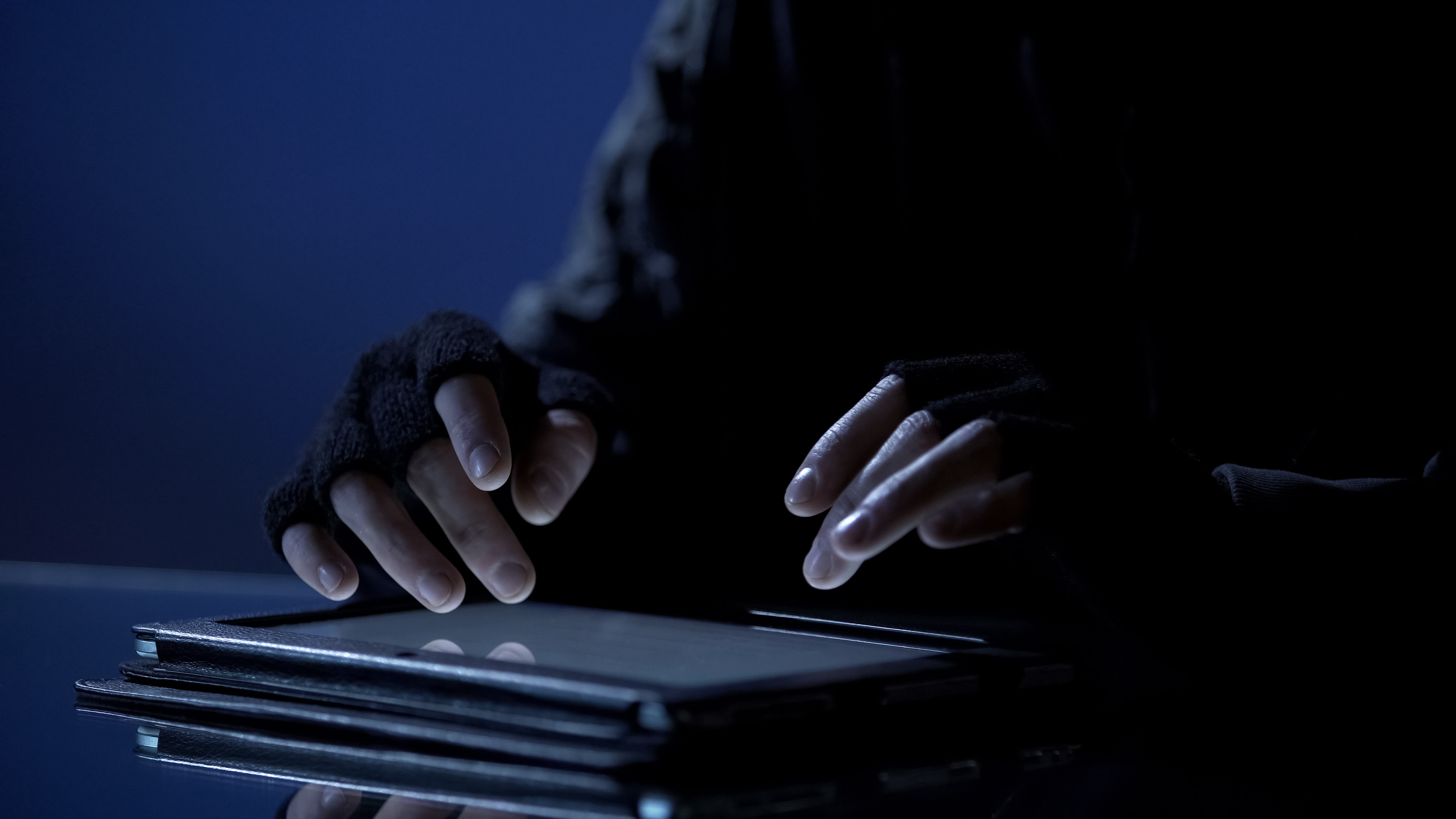 Man illegally viewing confidential files on a tablet. Photo: Shutterstock 