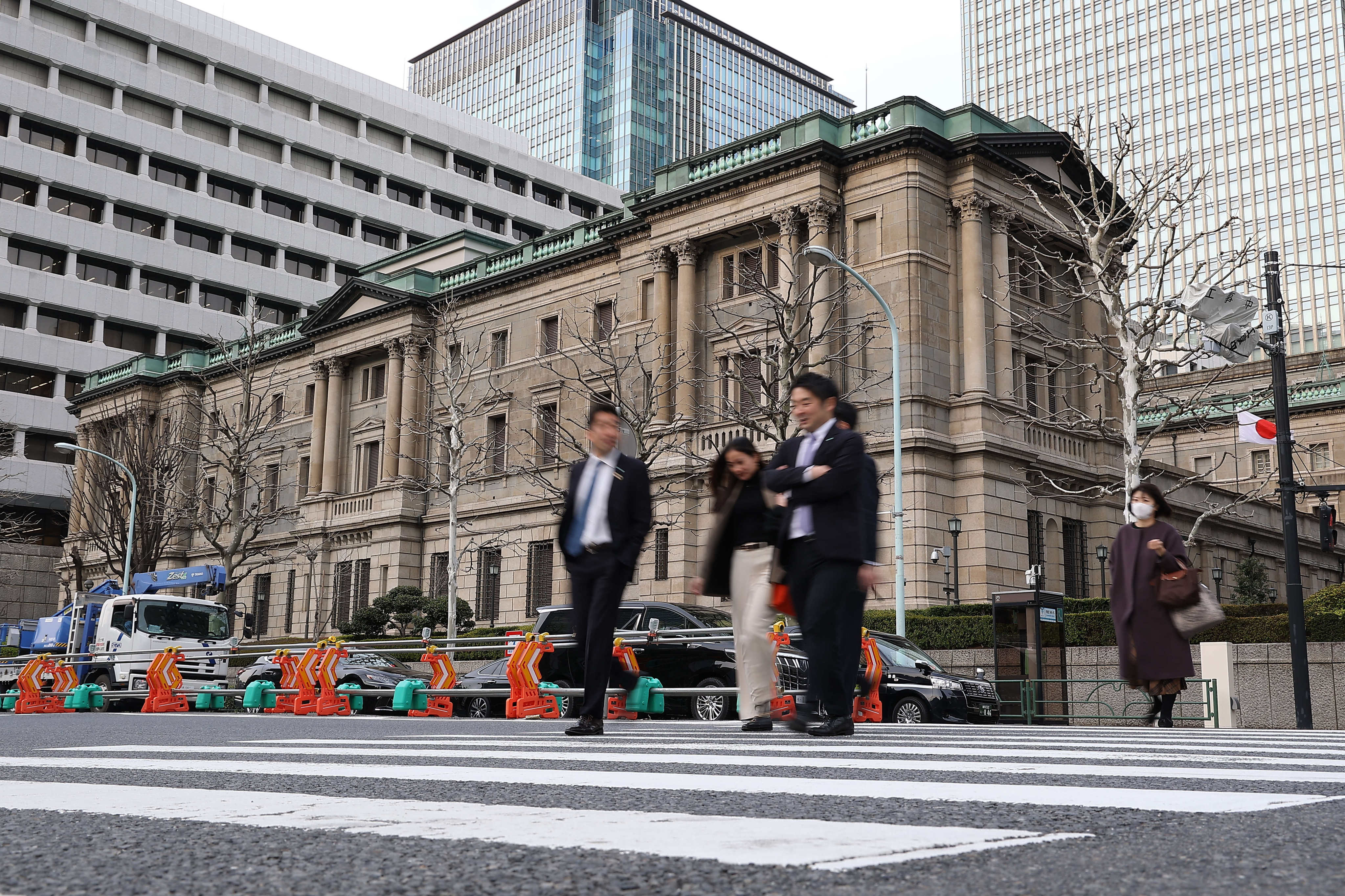 Pedestrians walk past the Bank of Japan headquarters in downtown Tokyo on March 19. Japan’s central bank has raised its key interest rate for the first time in 17 years, ending a long-standing policy of negative interest rates to stimulate the economy. Photo: dpa
