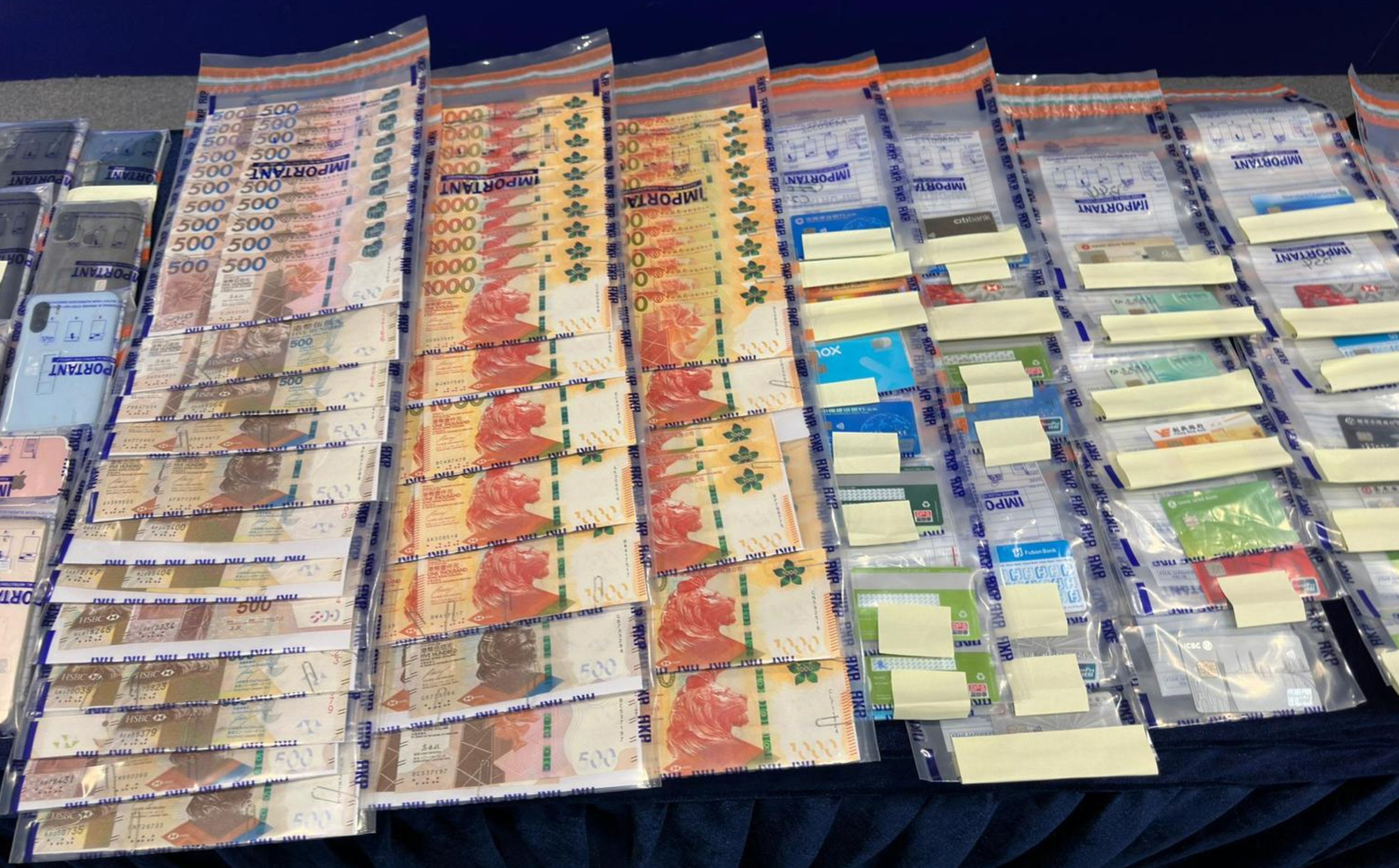 Evidence seized in the operation. Officers have confiscated HK$330,000 in cash, 57 bank cards and 40 mobile phones, among other items. Photo: Handout