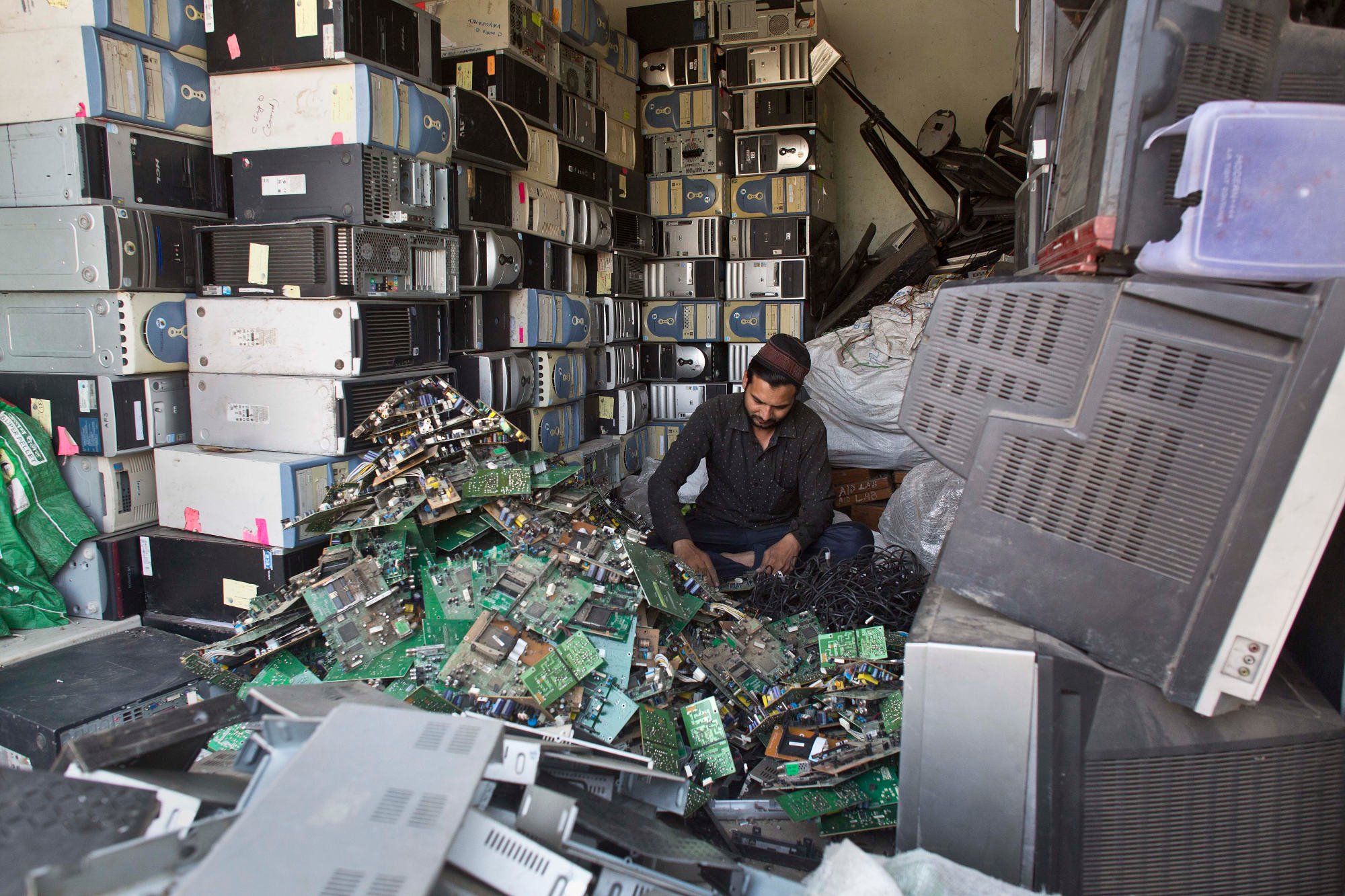 An Indian man works at an electronic waste recycling shop in Gauhati, Assam state, in 2017. Analysts say the “nerve centres” of many supply chains still remain in China. Photo: AP