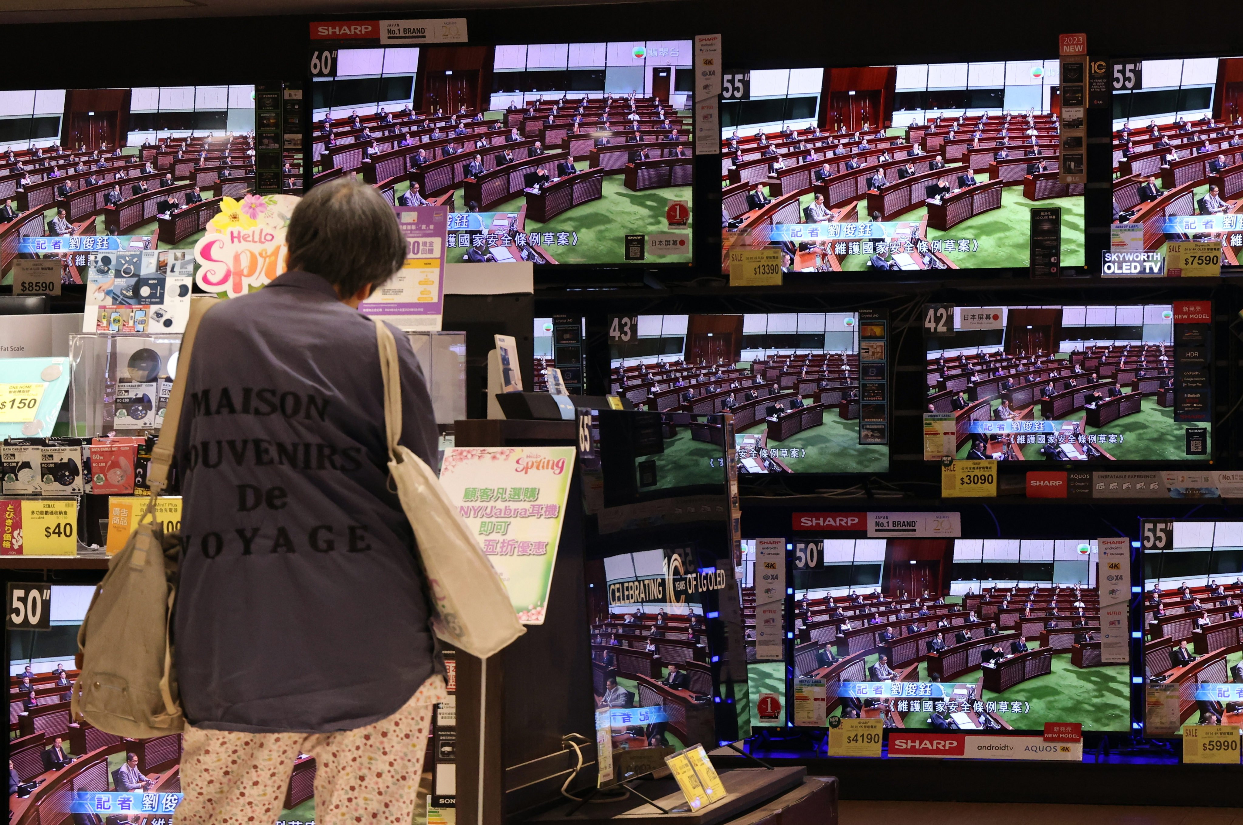 A shopper watches proceedings on television as Hong Kong lawmakers scrutinise the new domestic security bill. Photo: Jelly Tse