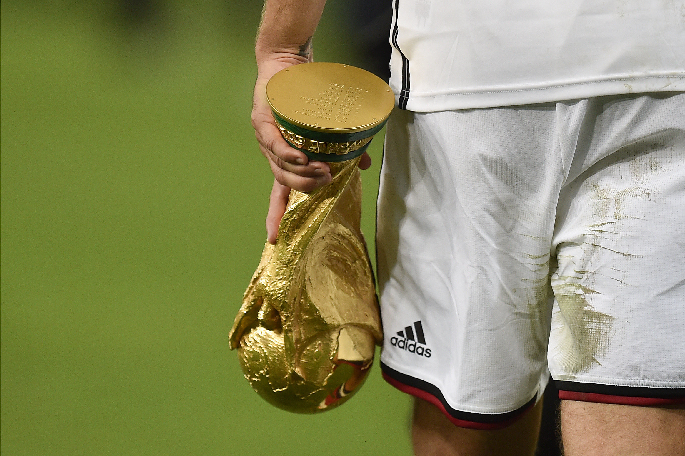 Germany’s Lukas Podolski  holds the World Cup trophy and wearing Adidas at the 2014 tournament. Photo: AP