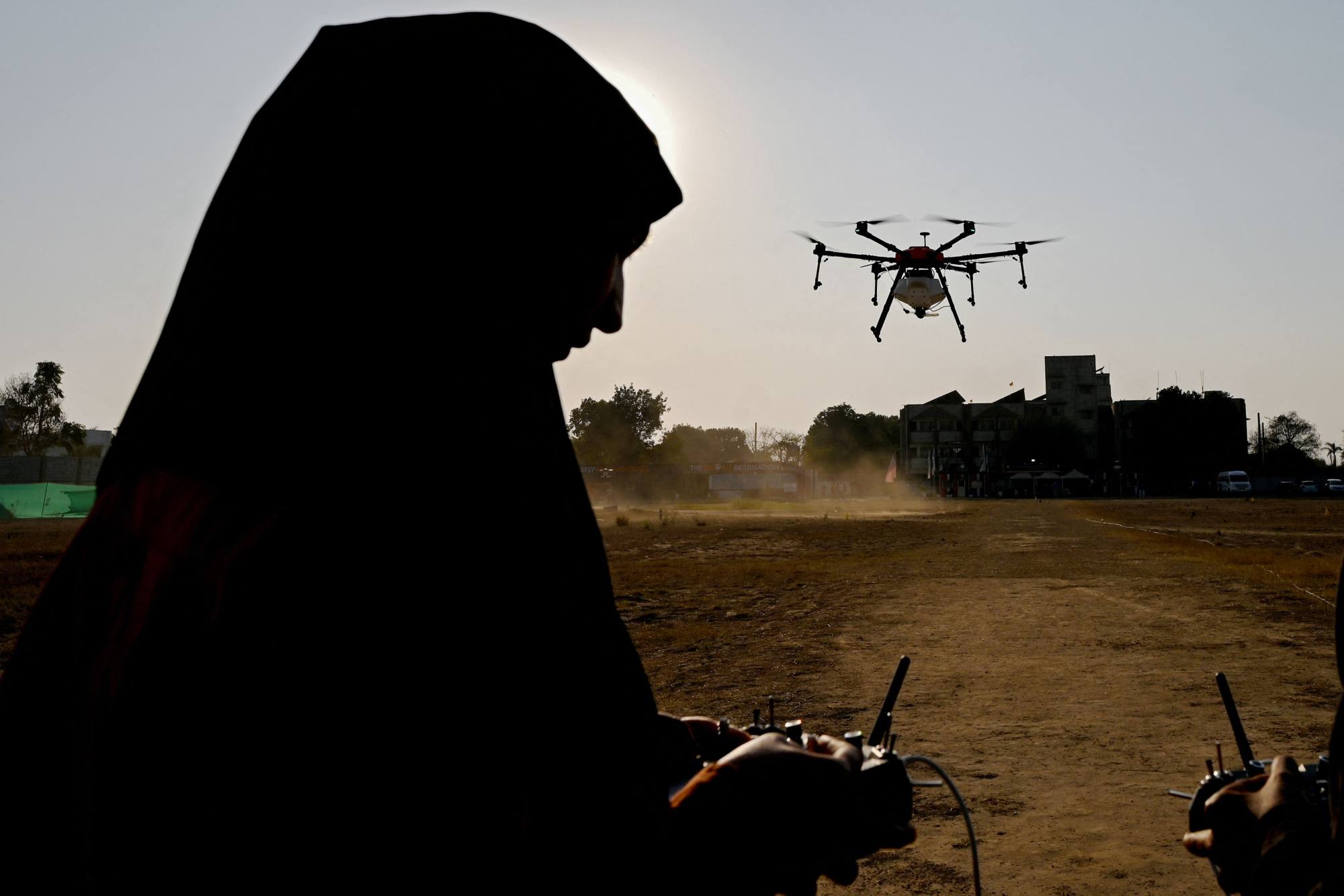 An Indian woman operates a fertiliser-spraying drone in Manesar, outside Delhi, as part of government-backed training initiative. India still needs to address glaring gaps between rural and urban infrastructure. Photo: AFP