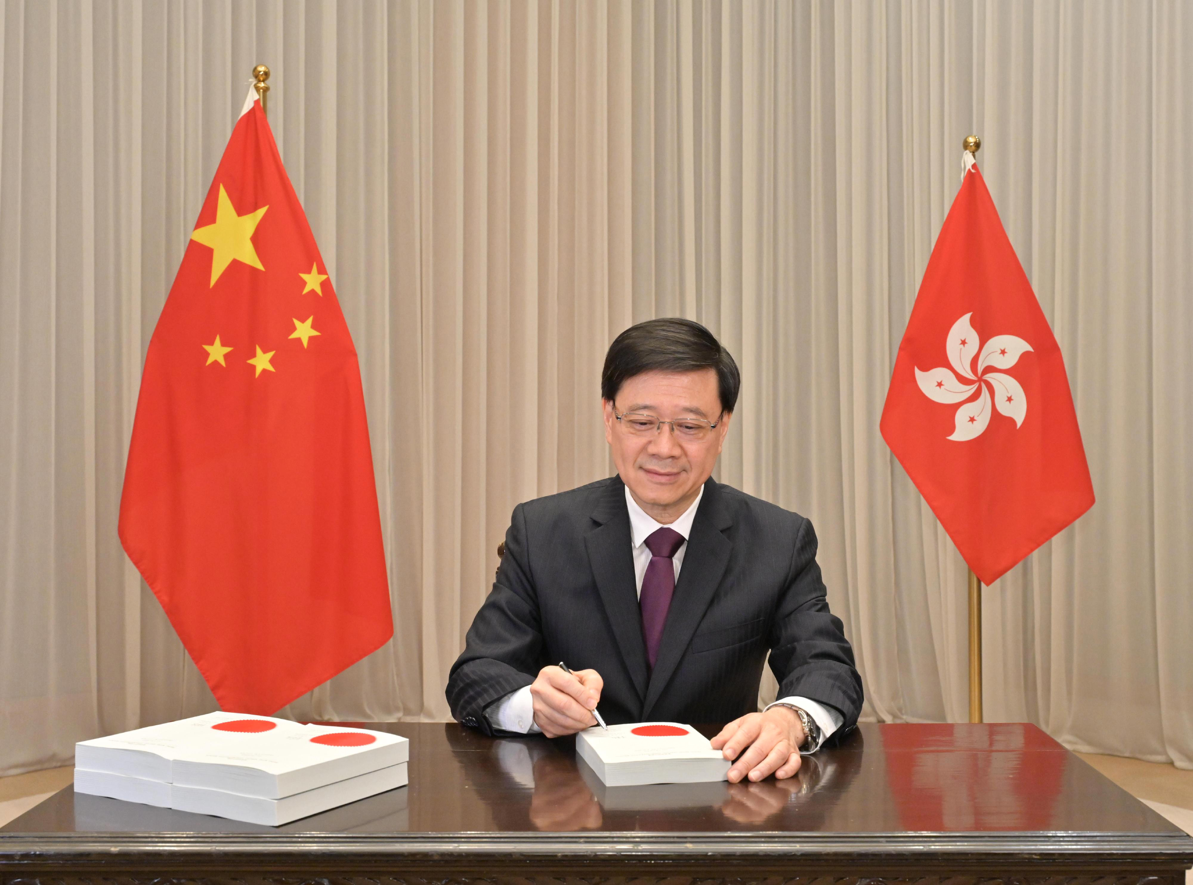 ​Hong Kong Chief Executive John Lee signs the Safeguarding National Security Ordinance into law on Friday. Photo: Handout 