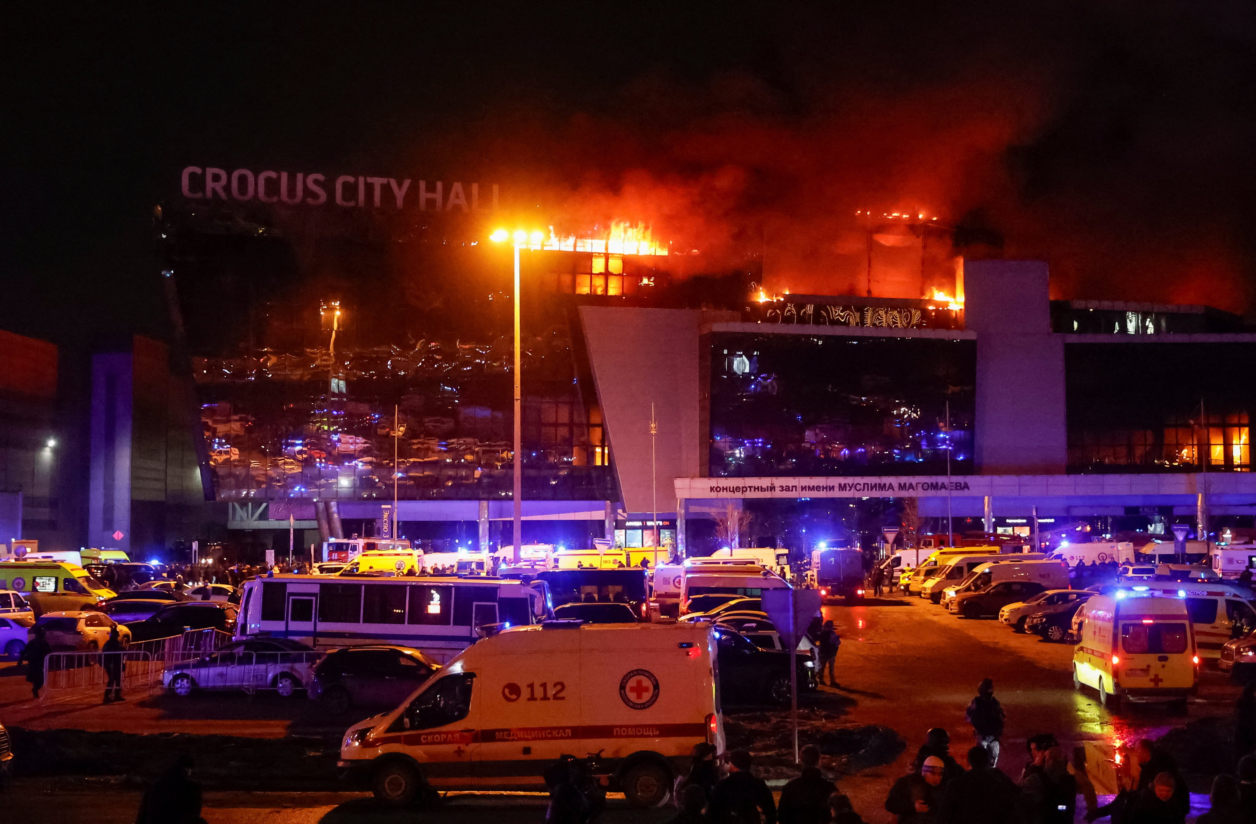 Ambulances and emergency vehicles sit outside the burning concert venue in Moscow, Russia where gunmen opened fire on Friday. Photo: Reuters