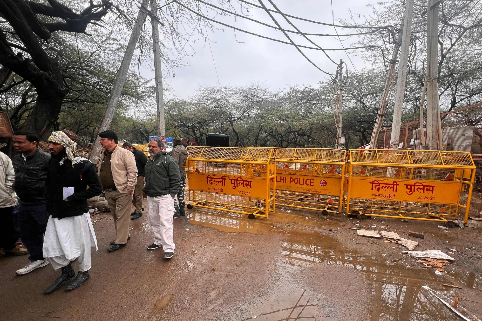 People gather near barriers placed at an entrance point to the site of a mosque demolished by local authorities over claims that it was an illegal construction in the Mehrauli area of New Delhi, India, on February 1. Photo: AFP