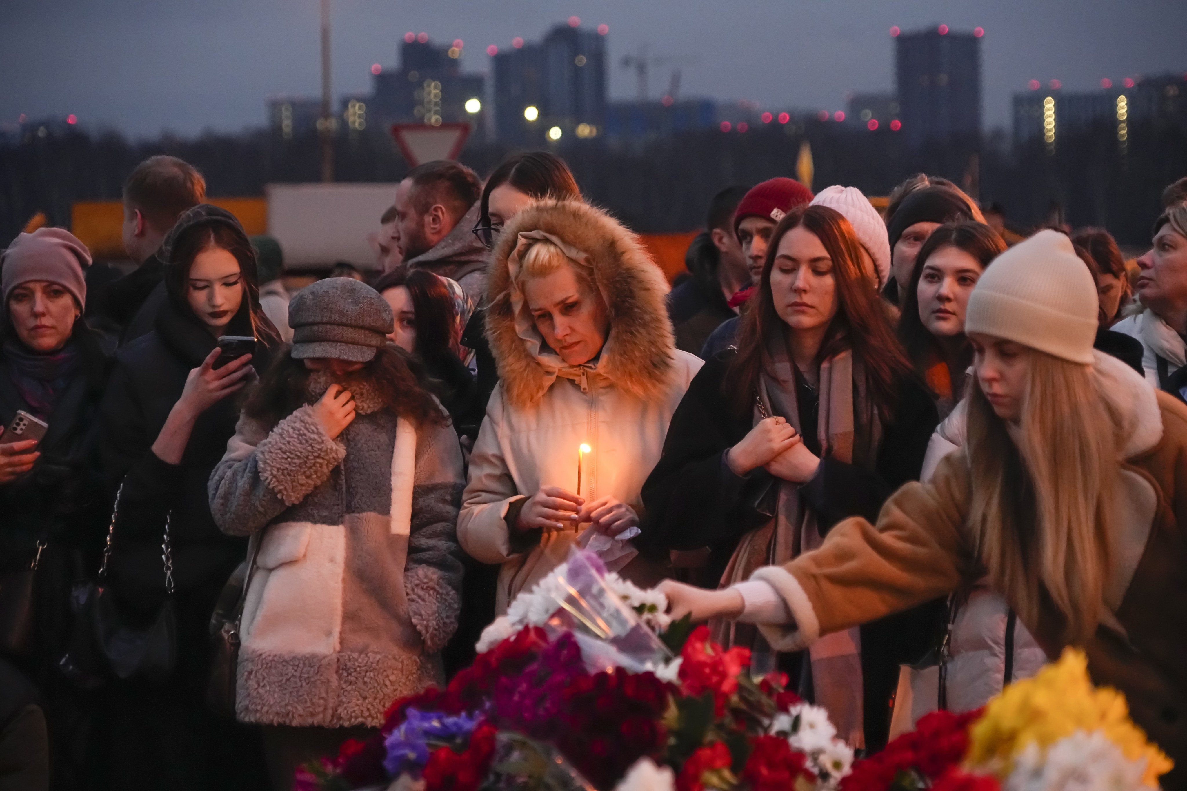 People lay flowers and light candles outside Crocus City Hall, on the western edge of Moscow, in Russia on Saturday. Photo: AP