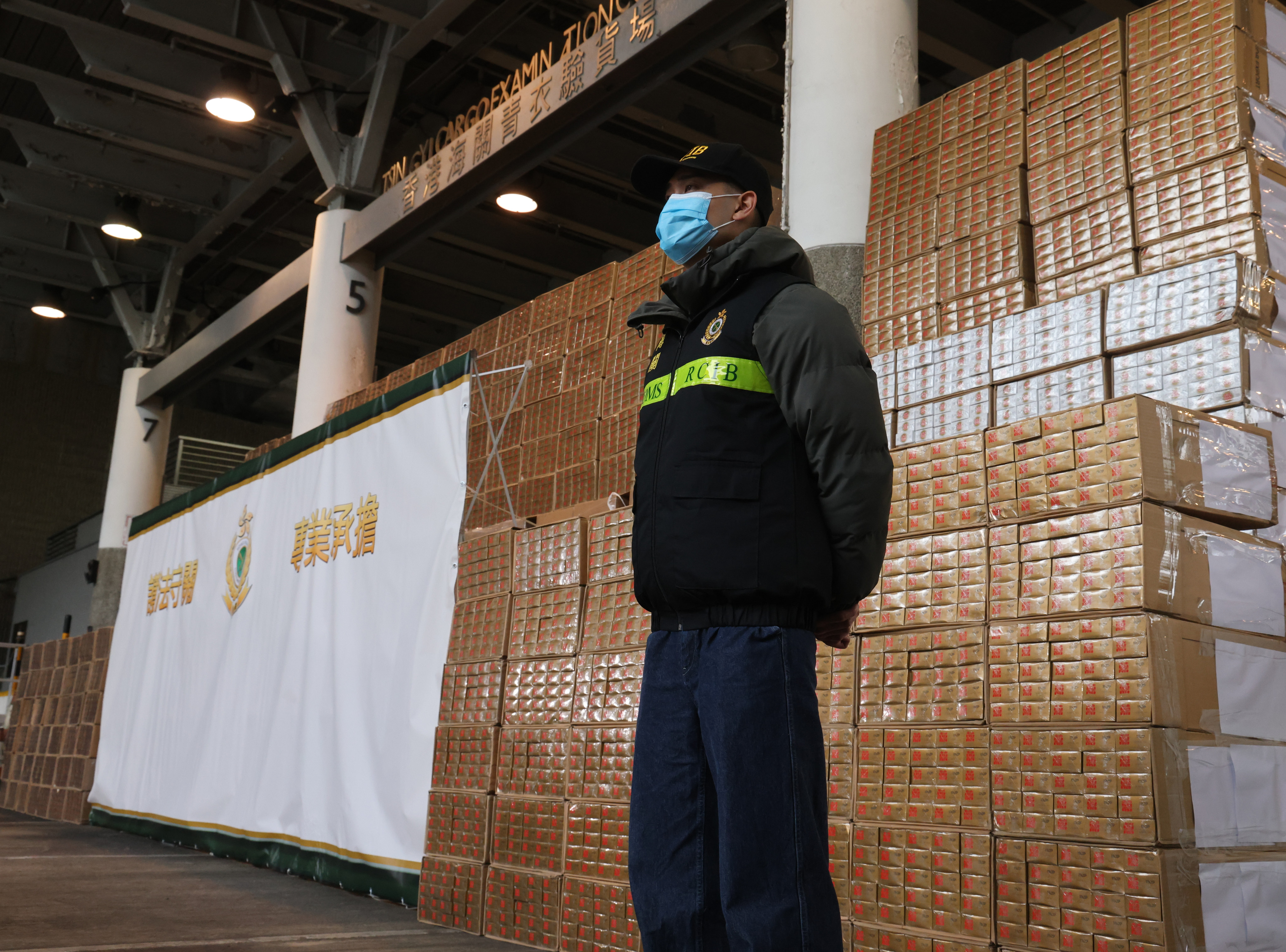 A customs officer stands guard over some of the millions of dollars worth of contraband cigarettes seized as part of the post-budget crackdown on contraband tobacco. Photo: Dickson Lee