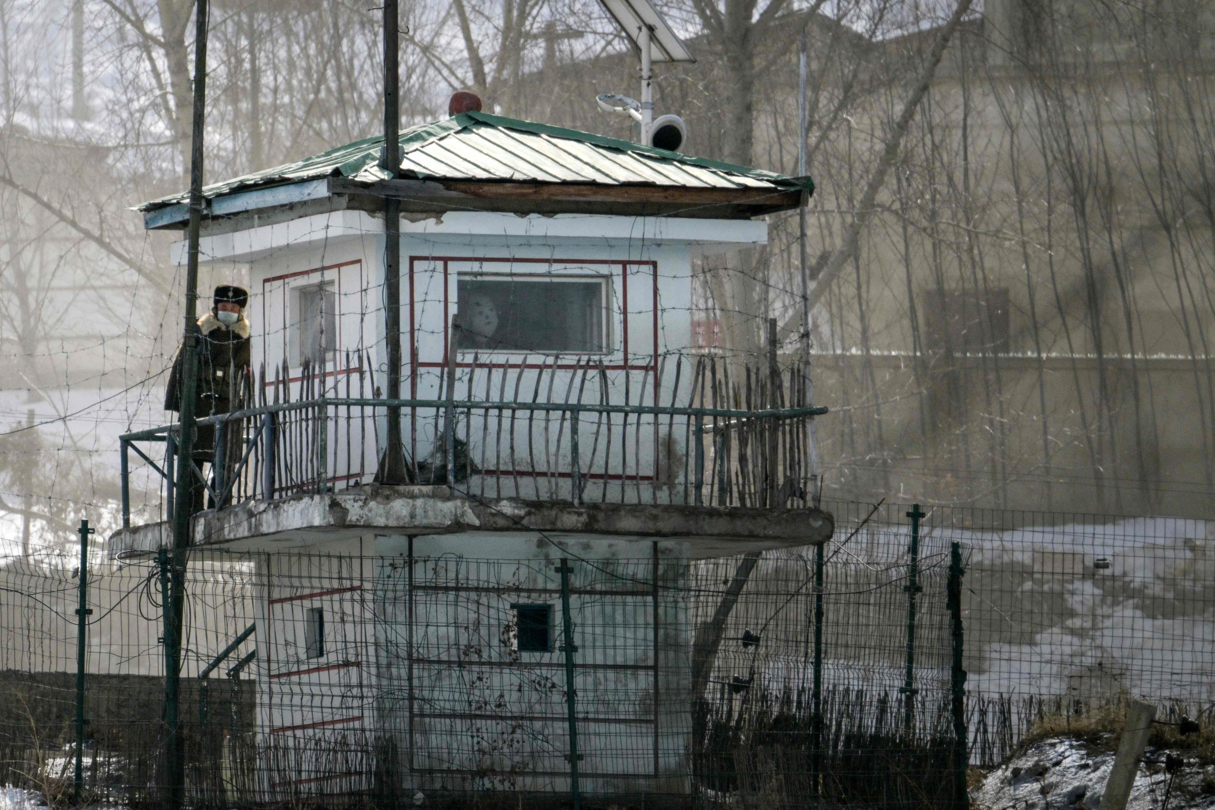 A border guard peers out from a watchtower in the North Korean village of Hyesan, as seen from Changbai in China’s northeastern Jilin province. Photo: AFP 