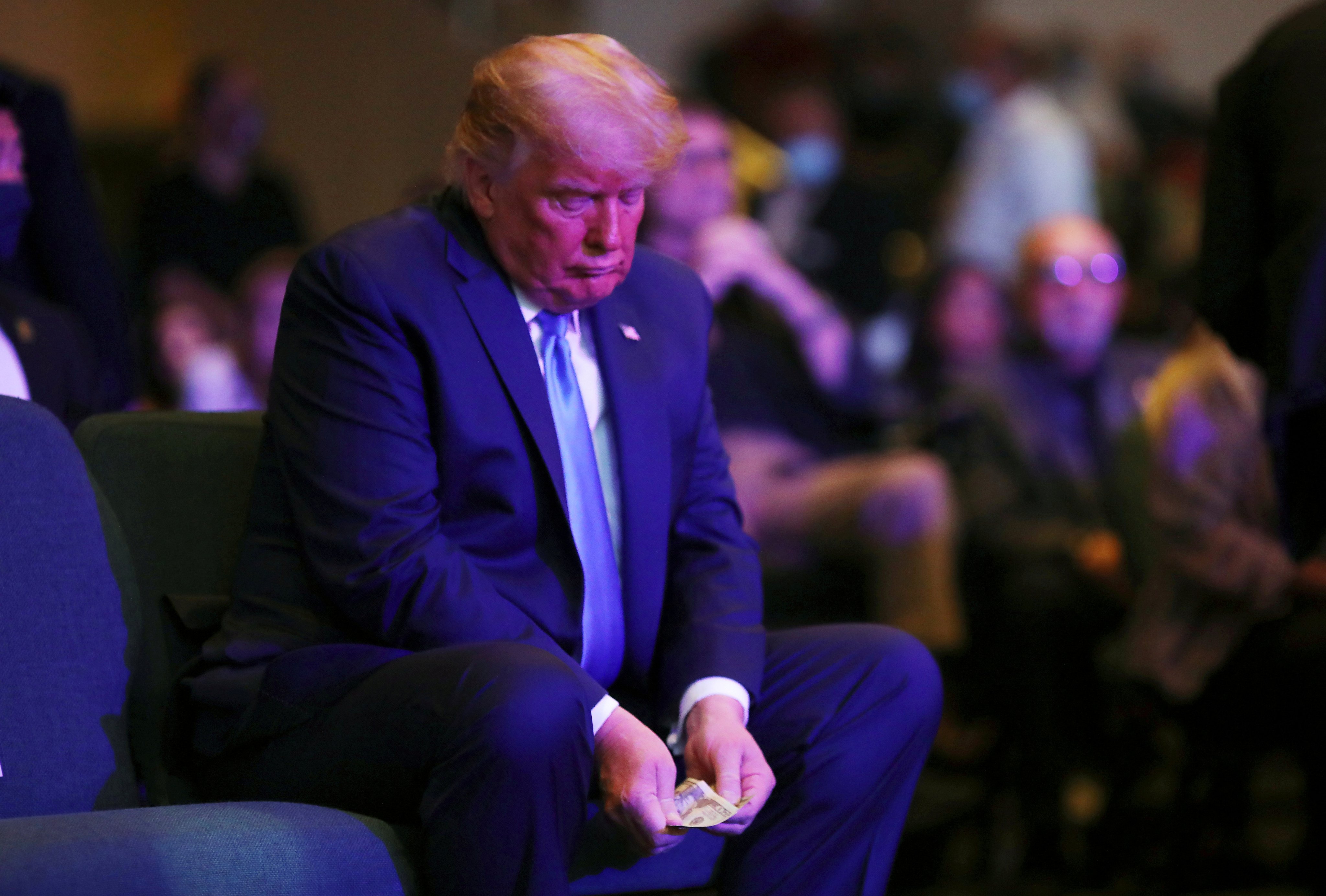 Trump counts money before donating to a church service in Las Vegas in 2020. He claims to have “almost” US$500 million in cash. Photo: Reuters