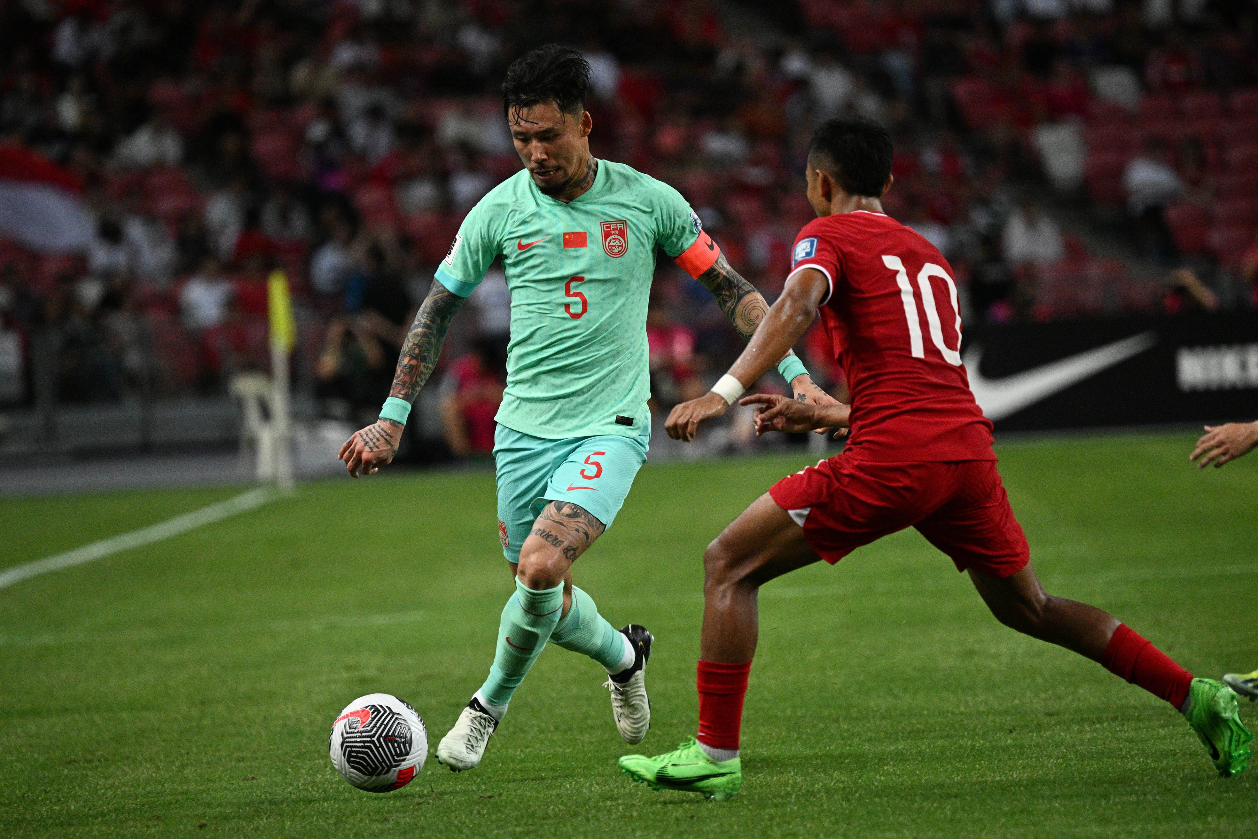 Chinese captain Zhang Linpeng (in green) has changed his mind on quitting the national team after China were held 2-2 by Singapore last Thursday. Photo: Xinhua