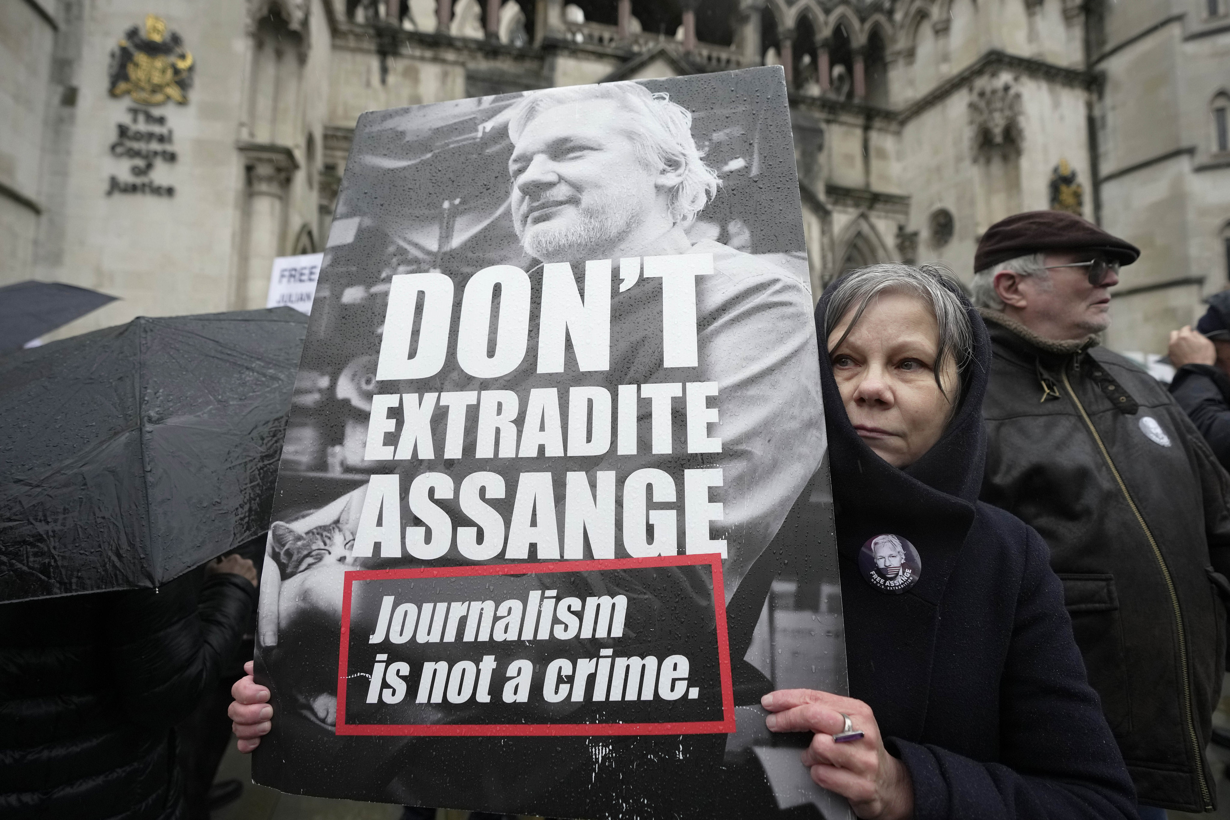 A protester holds a placard outside the Royal Courts of Justice in London on February 21. A London court will rule on Tuesday whether WikiLeaks founder Julian Assange can challenge extradition to the US on espionage charges. Photo: AP
