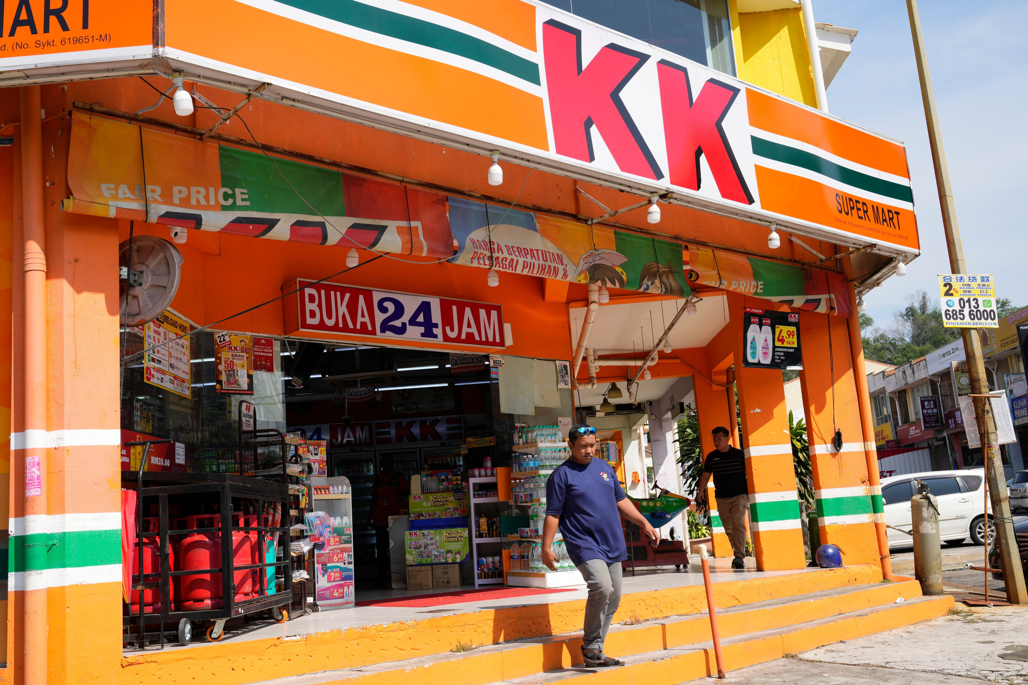 A customer walk out from KK Mart convenience store in Puchong area on the outskirts of of Kuala Lumpur. KK Super Mart and its supplier has apologised for the socks. Photo: AP