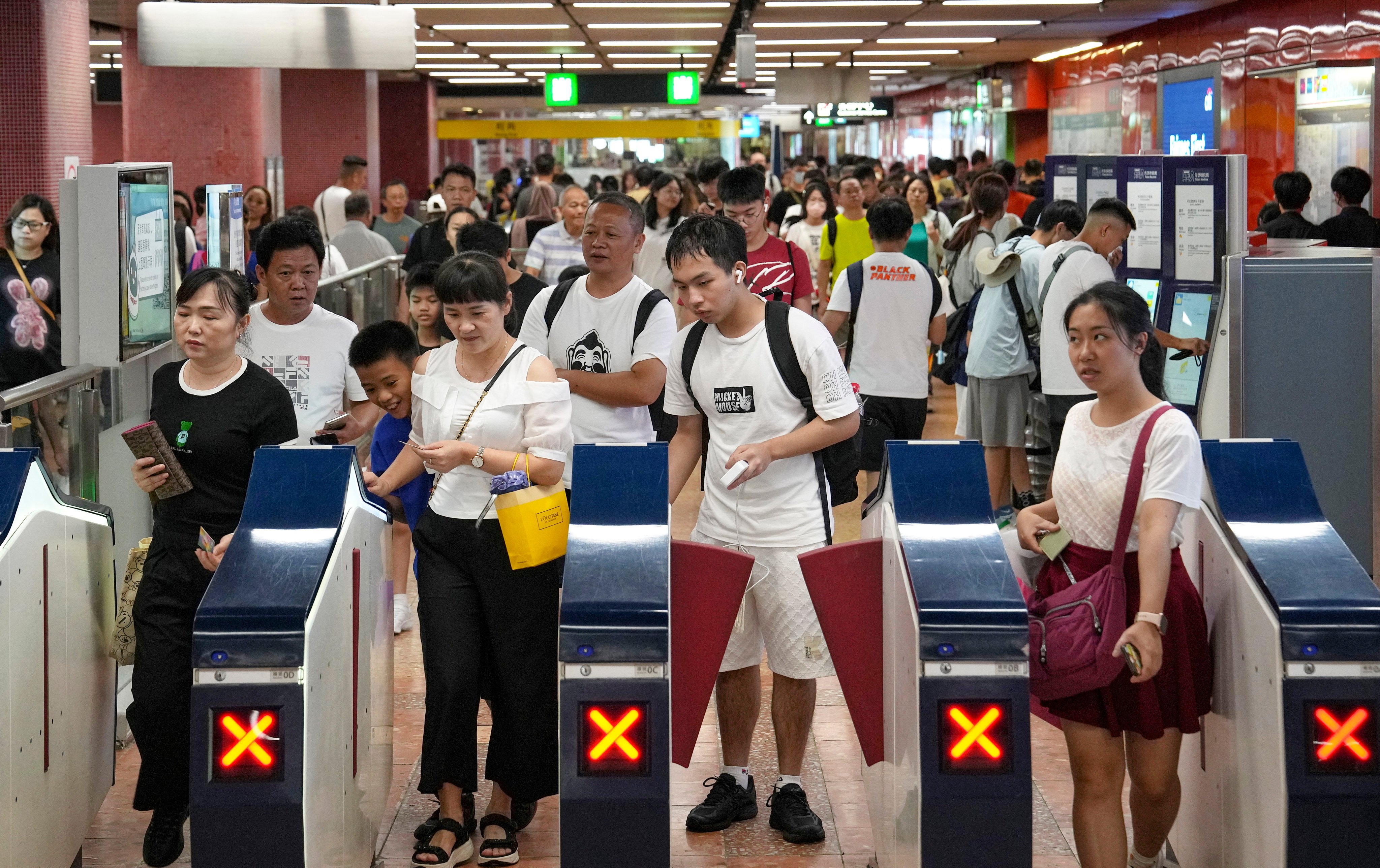Passengers passing through payment gates of Mong Kok MTR station. The fare adjustment mechanism is set to be used for five financial years. Photo: Elson Li