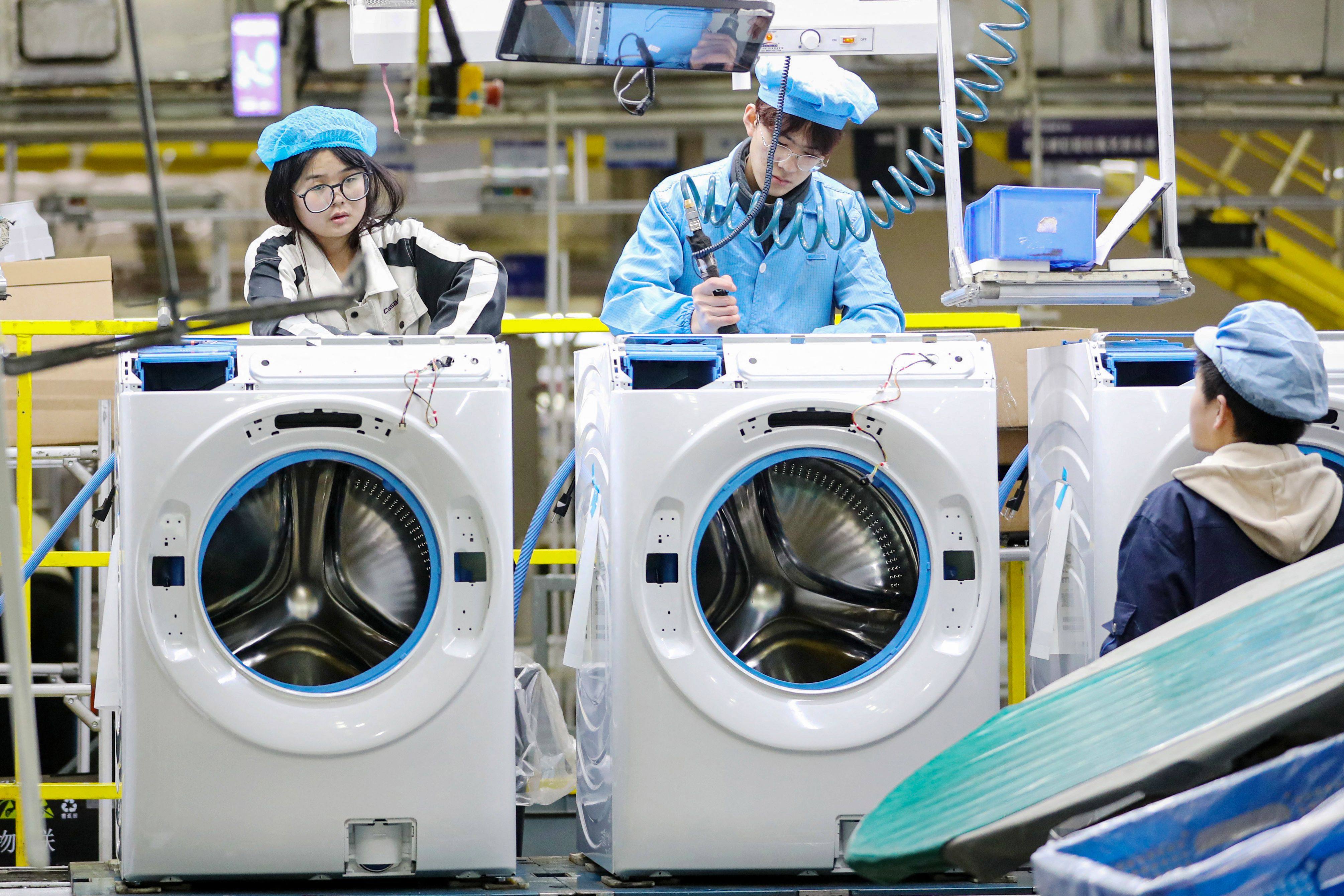 Employees work on a washing machine production line at a factory for Chinese home appliances and consumer electronics company Haier in Qingdao, in eastern China’s Shandong province on February 18, 2024. Its shares jumped after the company posted better-than-estimated full-year results. Photo:AFP