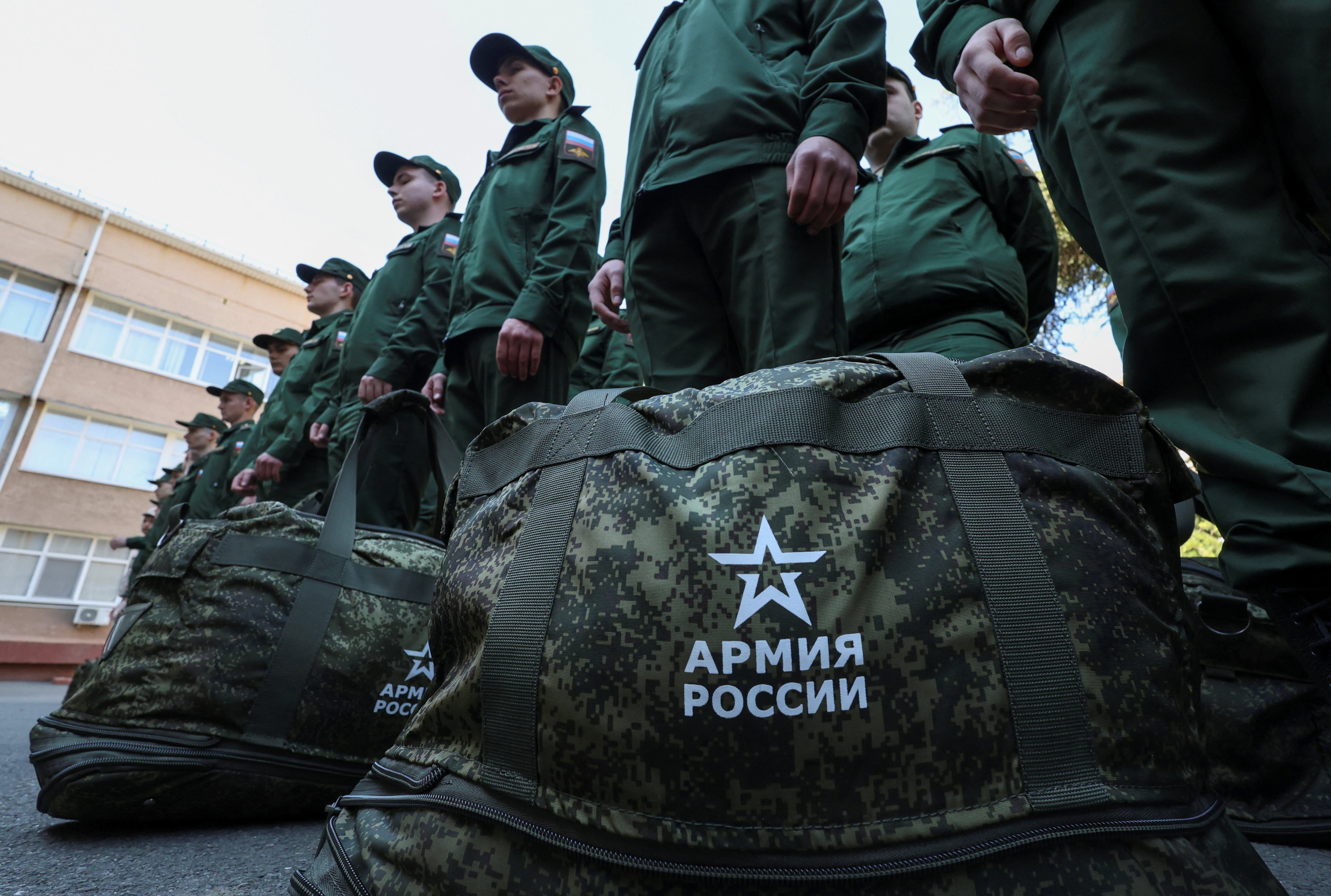 Russian conscripts called up for military service line up before their departure for garrisons as they gather at a recruitment centre in Simferopol, Crimea on April 25, 2023. Signs on bags read: “Army of Russia”. Photo: Reuters