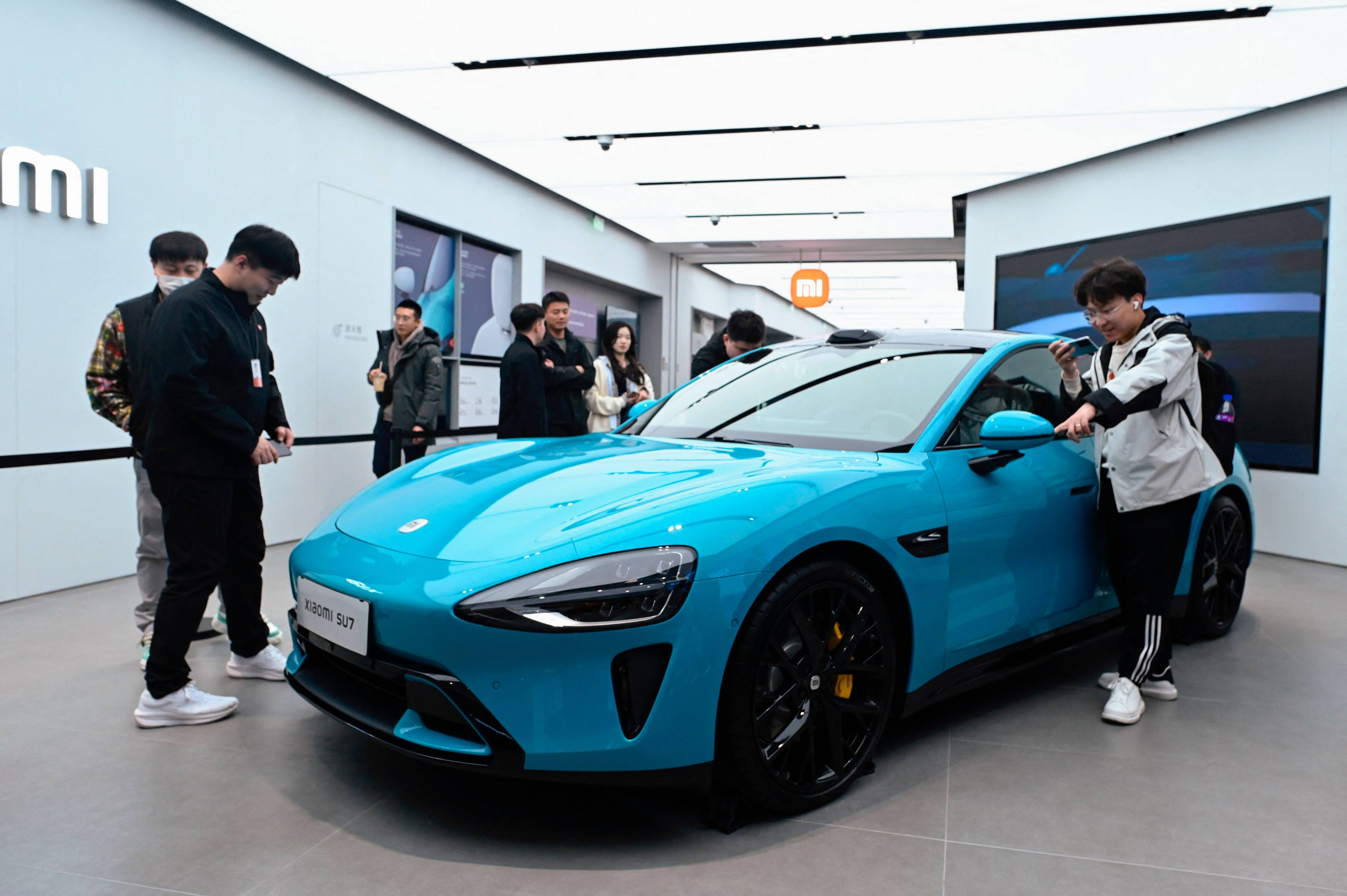 People look at a Xiaomi SU7 electric car displayed at a Xiaomi store in Beijing on March 26, 2024. Photo: AFP 