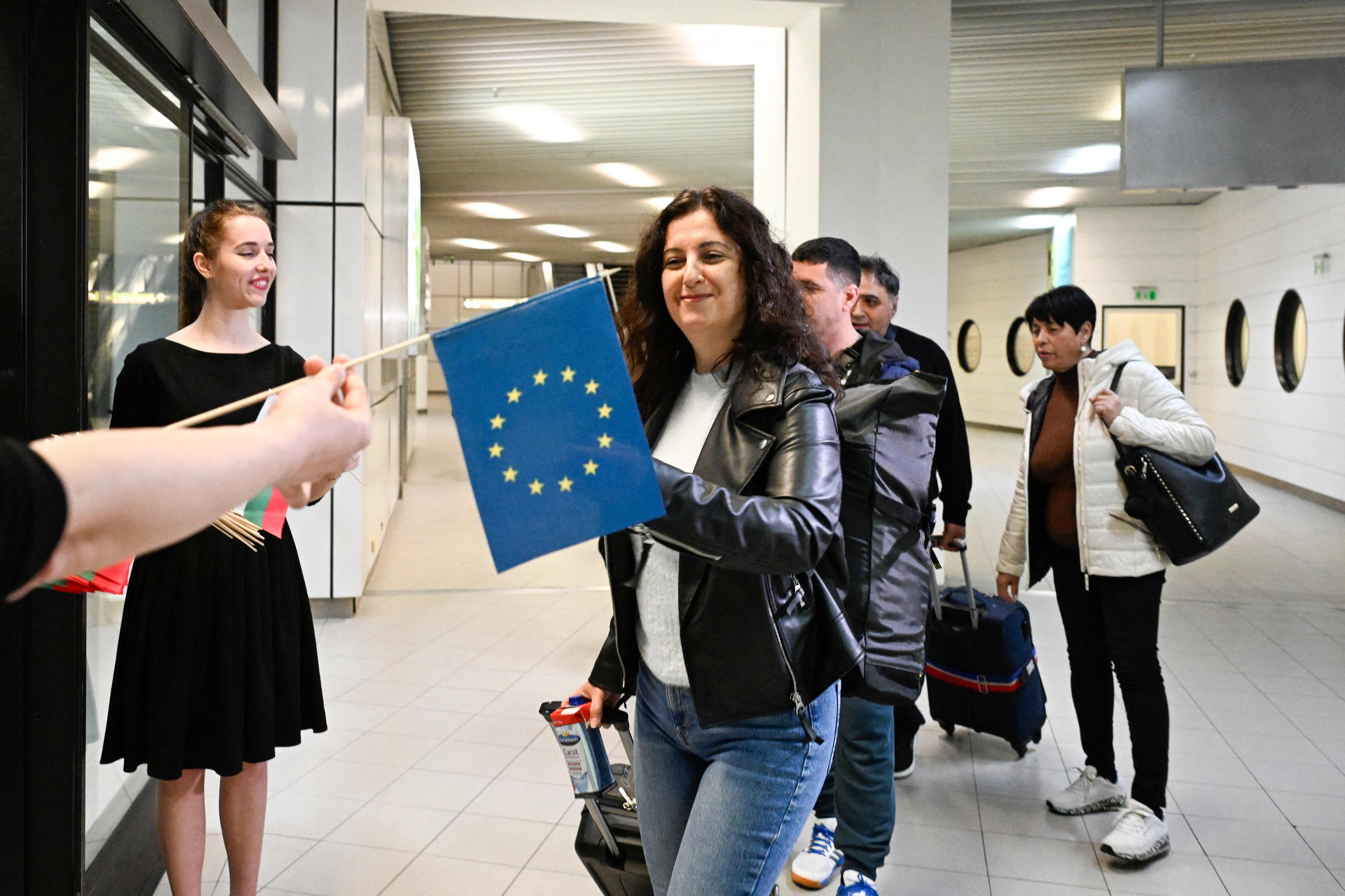 Passengers arriving from Berlin receive European Union and Bulgarian flags after Bulgaria’s official partial entry into Europe’s open-borders Schengen area at Sofia airport on Sunday. Photo: AFP