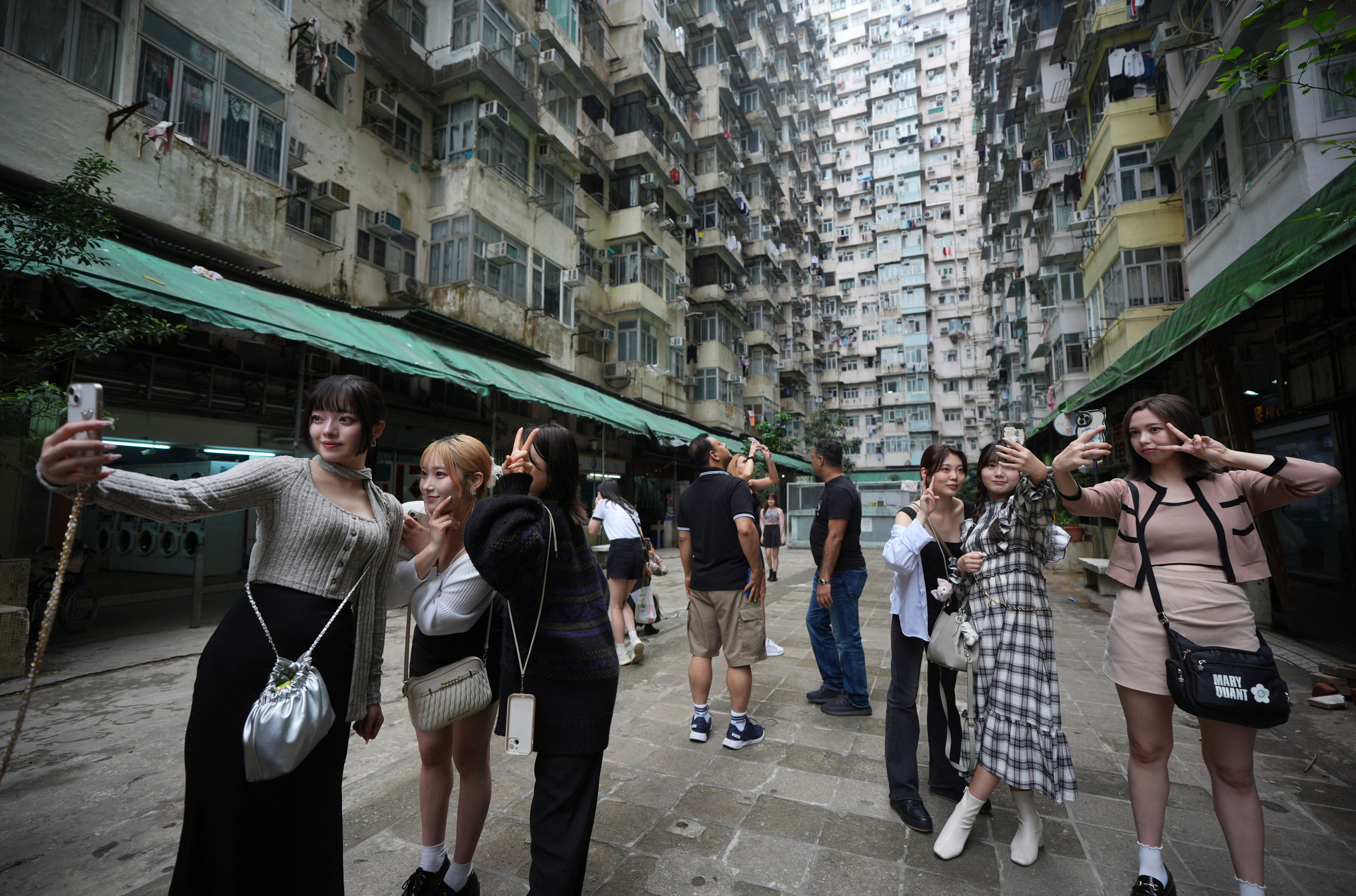 Tourists take pictures near the Yick Cheong Building, also known as the “Monster Building”, in Quarry Bay, Hong Kong. Photo: Eugene Lee