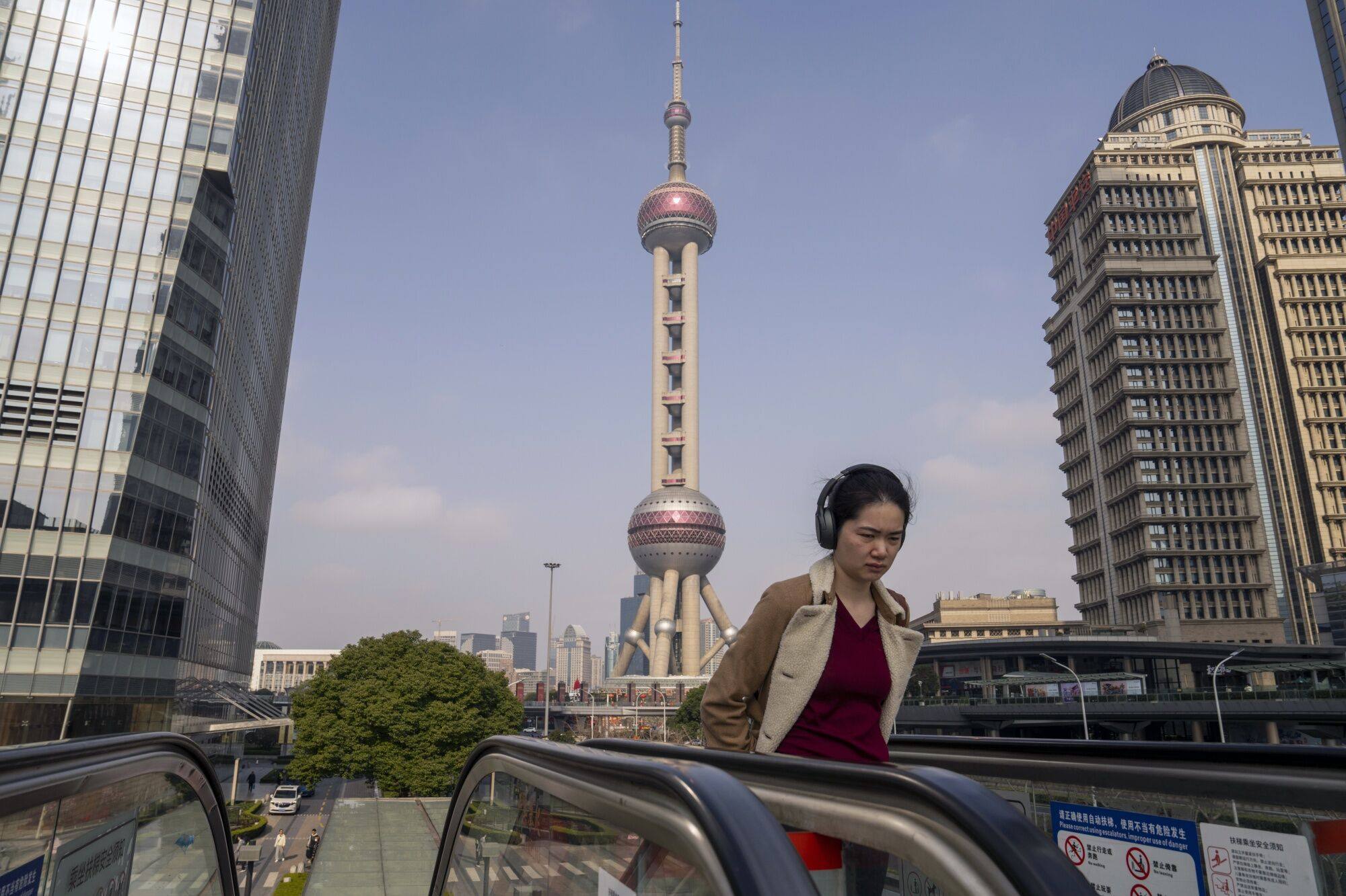 A pedestrian rides an escalator in Pudong’s Lujiazui Financial District in Shanghai, China. Photo: Bloomberg