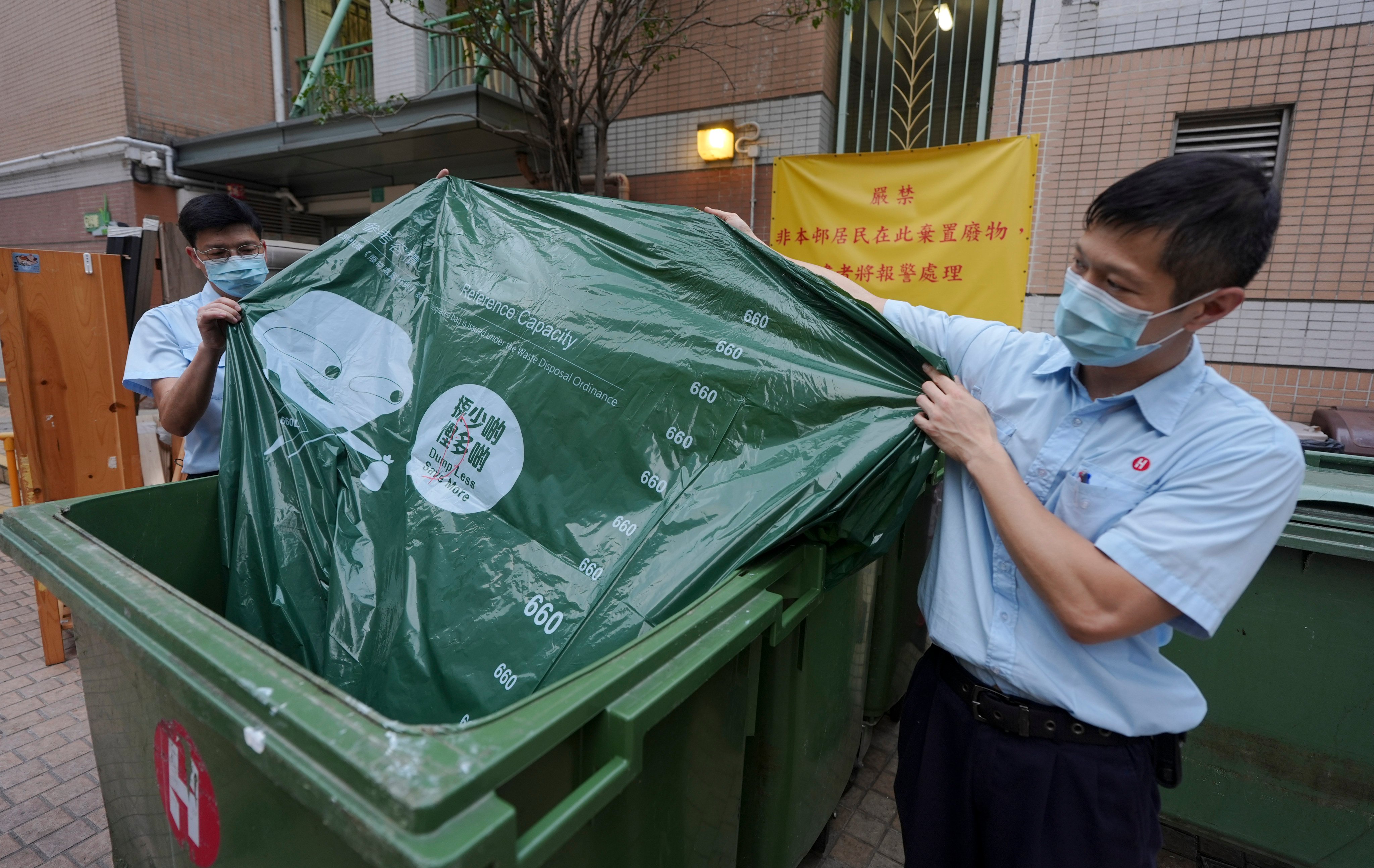 Property management officers with designated bags for waste disposal at On Ning House, Moon Lok Dai Ha, in Tseun Wan. Photo: Eugene Lee