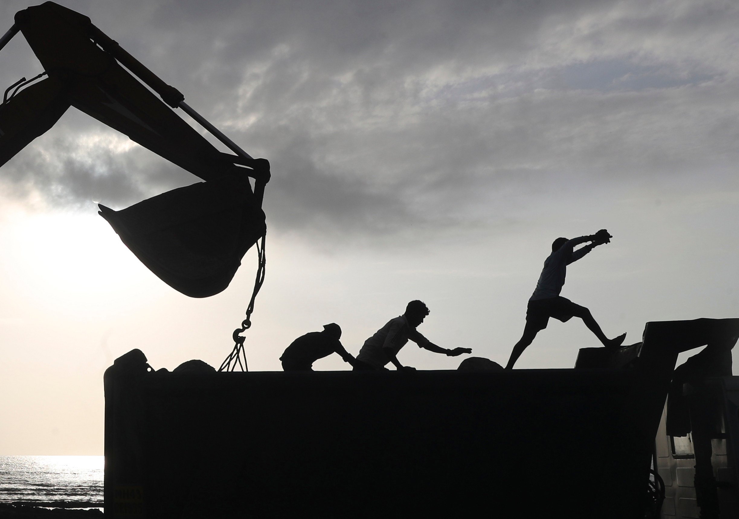 Workers use machinery at the construction site for a coastal road project in Mumbai, India. Photo: AP