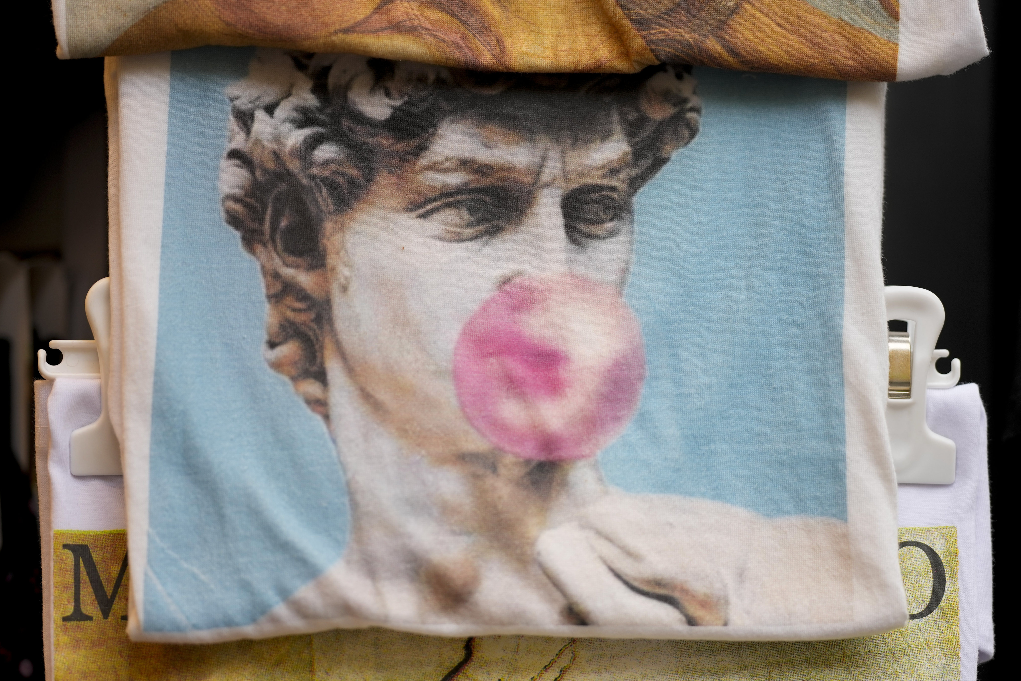 A souvenir bag shows Michelangelo’s David blowing a gum bubble among other souvenirs in a shop in Florence, Italy, on March 18, 2024. Legal efforts to restrict vendors from debasing the statue’s image have prompted debate across Italy about restrictions on freedom of expression. Photo: AP
