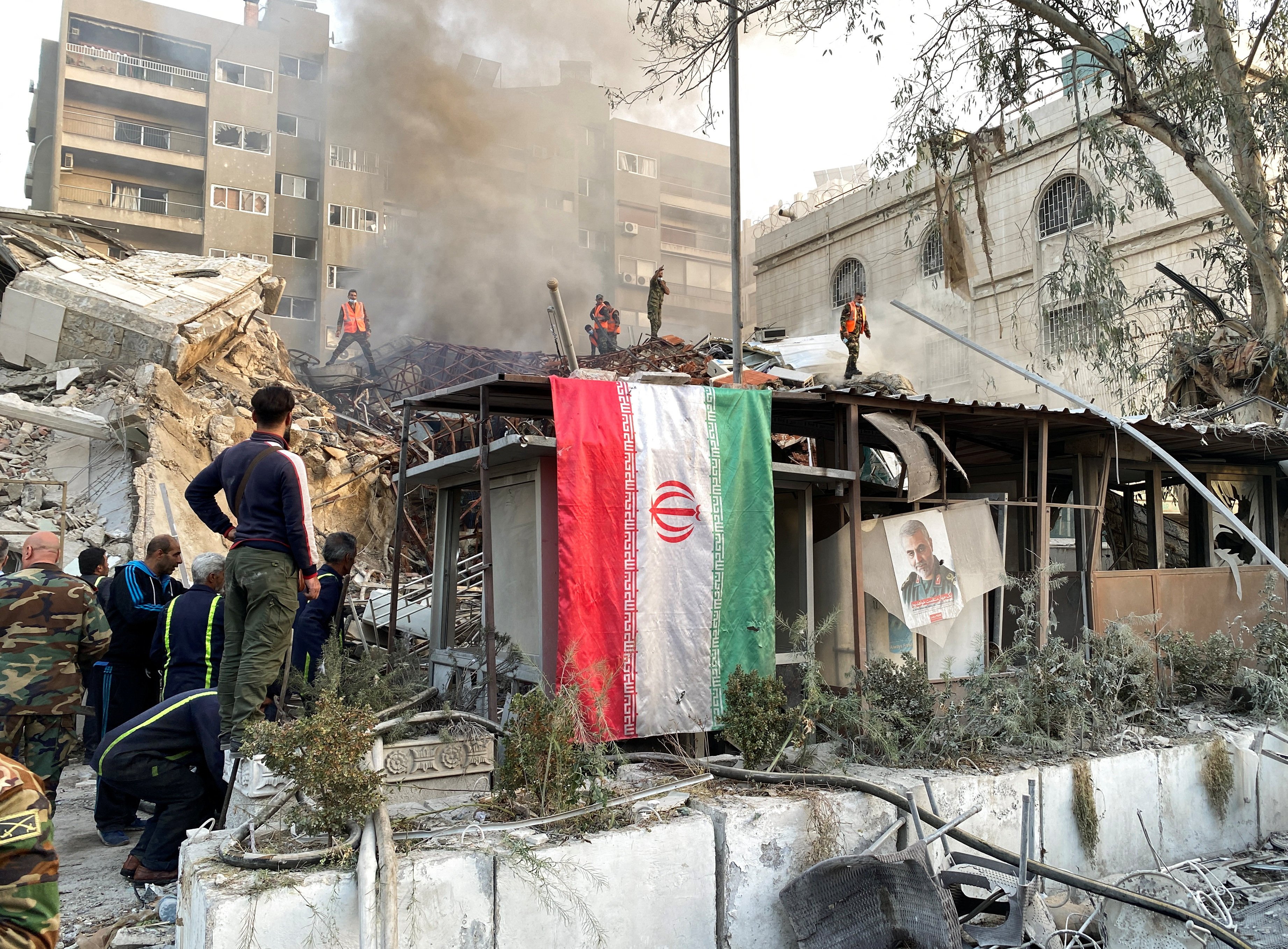 An Iranian flag hangs as smoke rises after what Iranian media said was an Israeli strike on a building close to the Iranian embassy in Damascus, Syria  on Monday. Photo: Reuters 