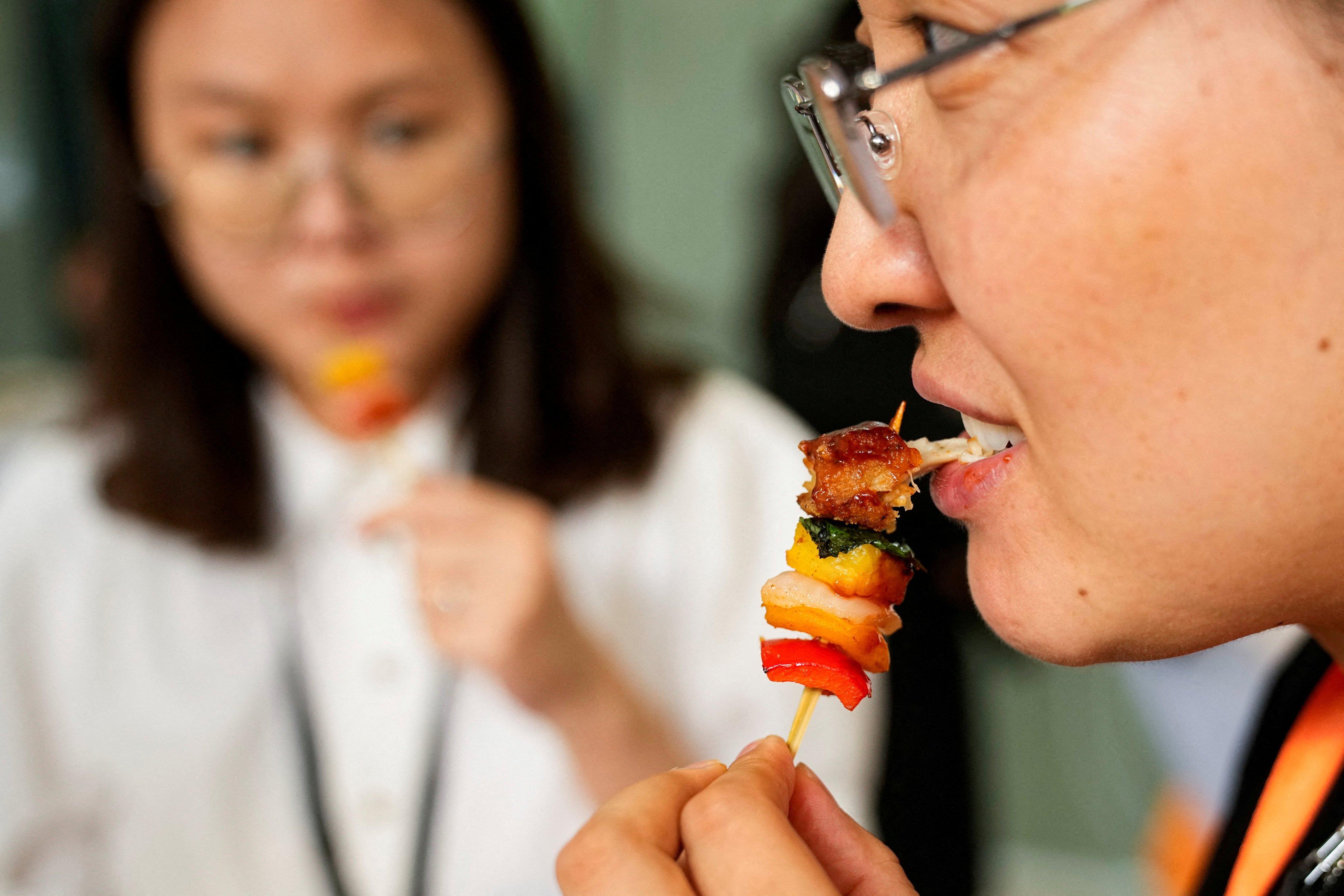 A woman tastes lab-grown meat served by CellX at an event to mark the opening of the cultivated meat company’s pilot production facility in Shanghai, China August 9, 2023. Photo: Reuters