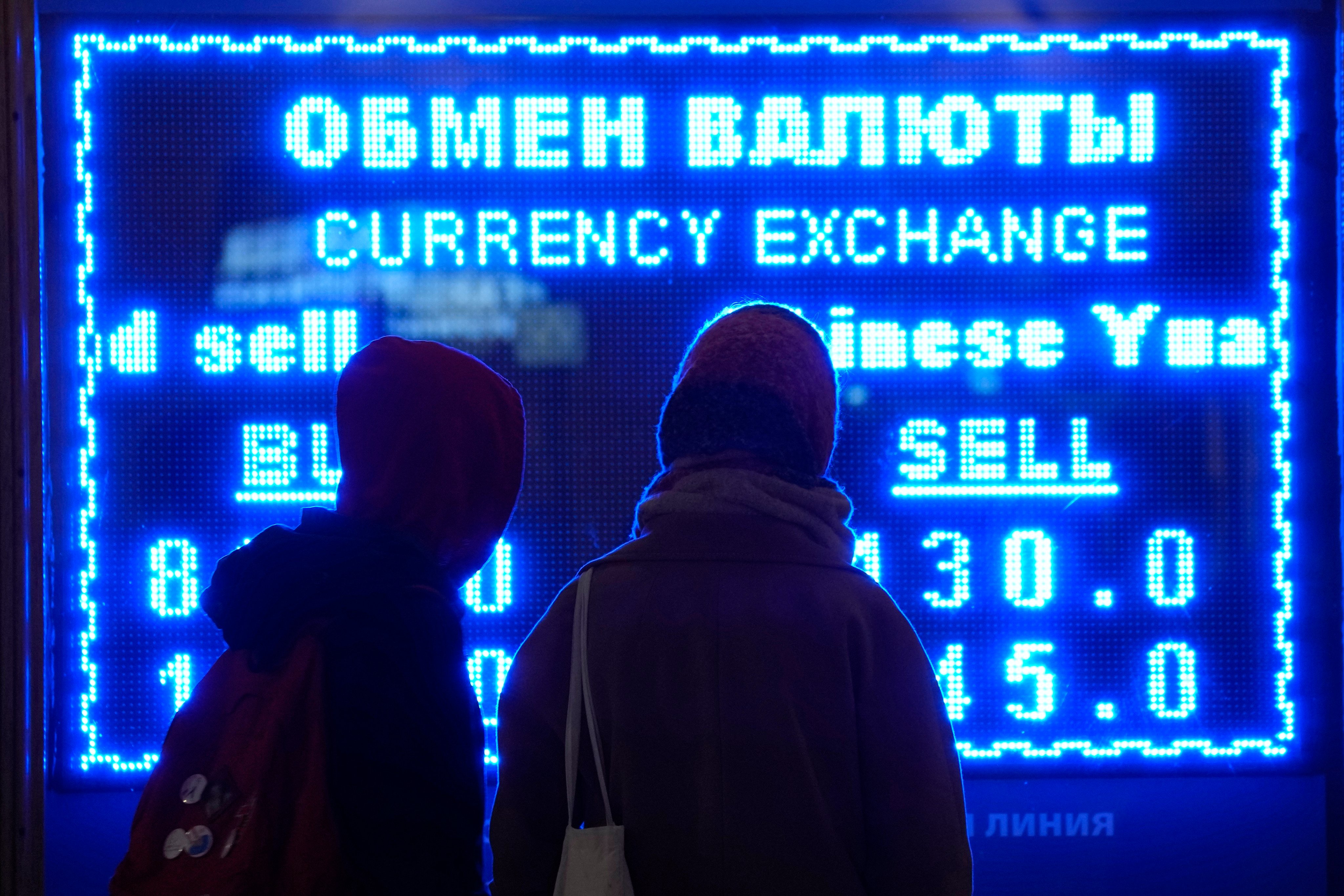 Women look at a screen showing the exchange rate at a currency exchange office in St Petersburg, Russia on March 1, 2022 as the Russian currency plunges against the US dollar after Western nations announced moves to block some Russian banks from the Swift international payment system. Photo: AP