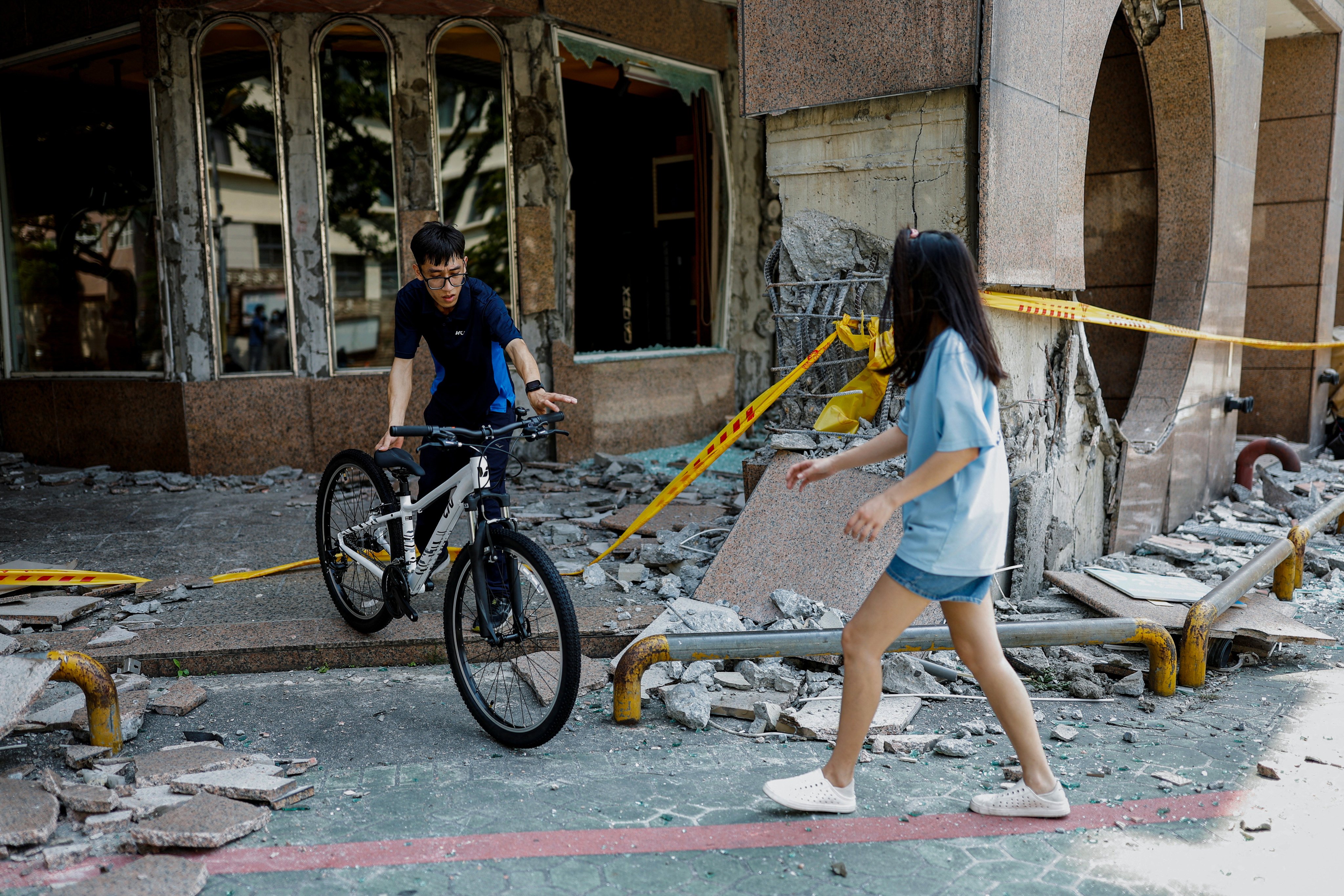 People move a bicycle from the rubble in Hualien. Photo: Reuters