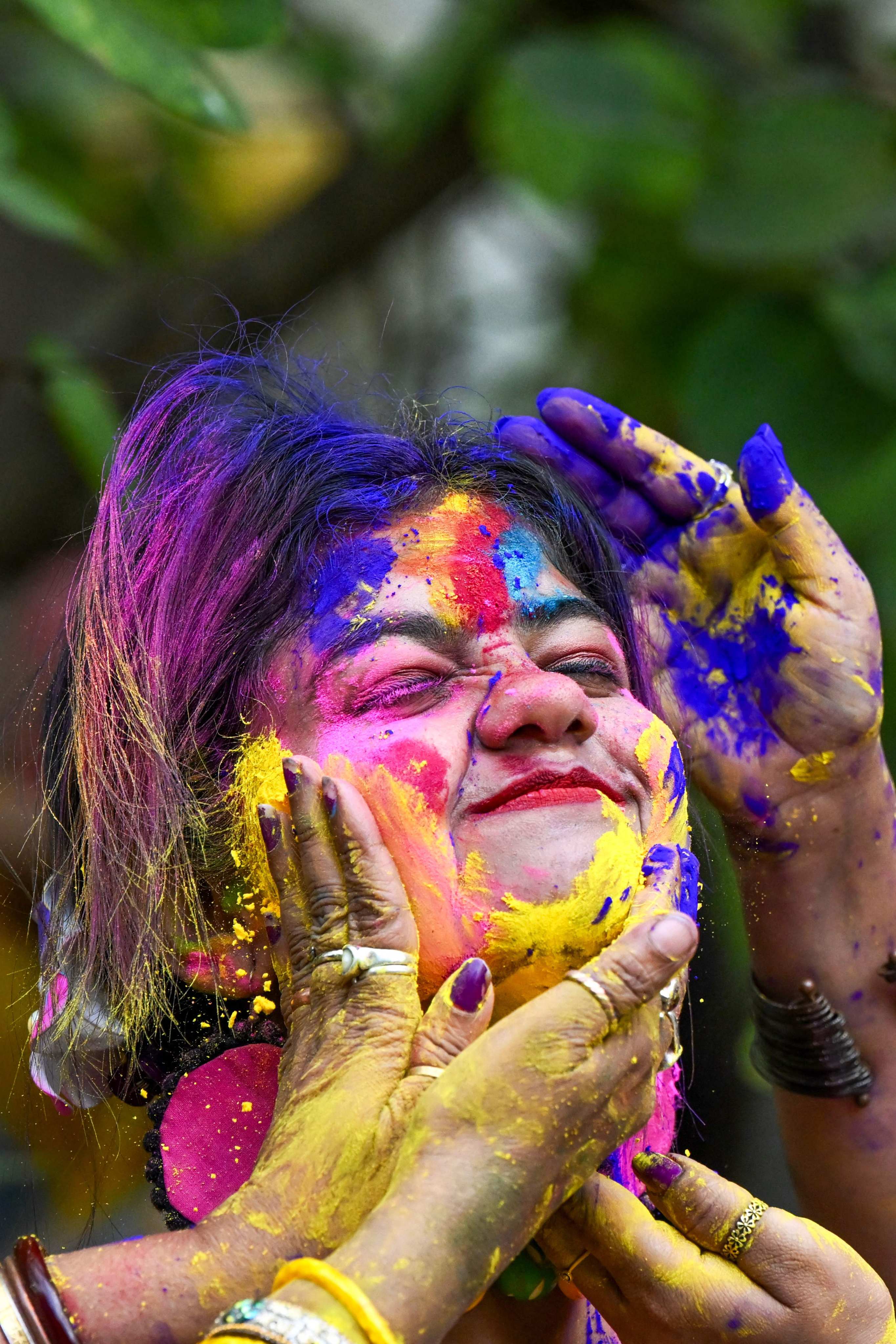 A woman is smeared with colourful powder as she celebrates Holi, the Hindu spring festival of colours. Photo: AFP