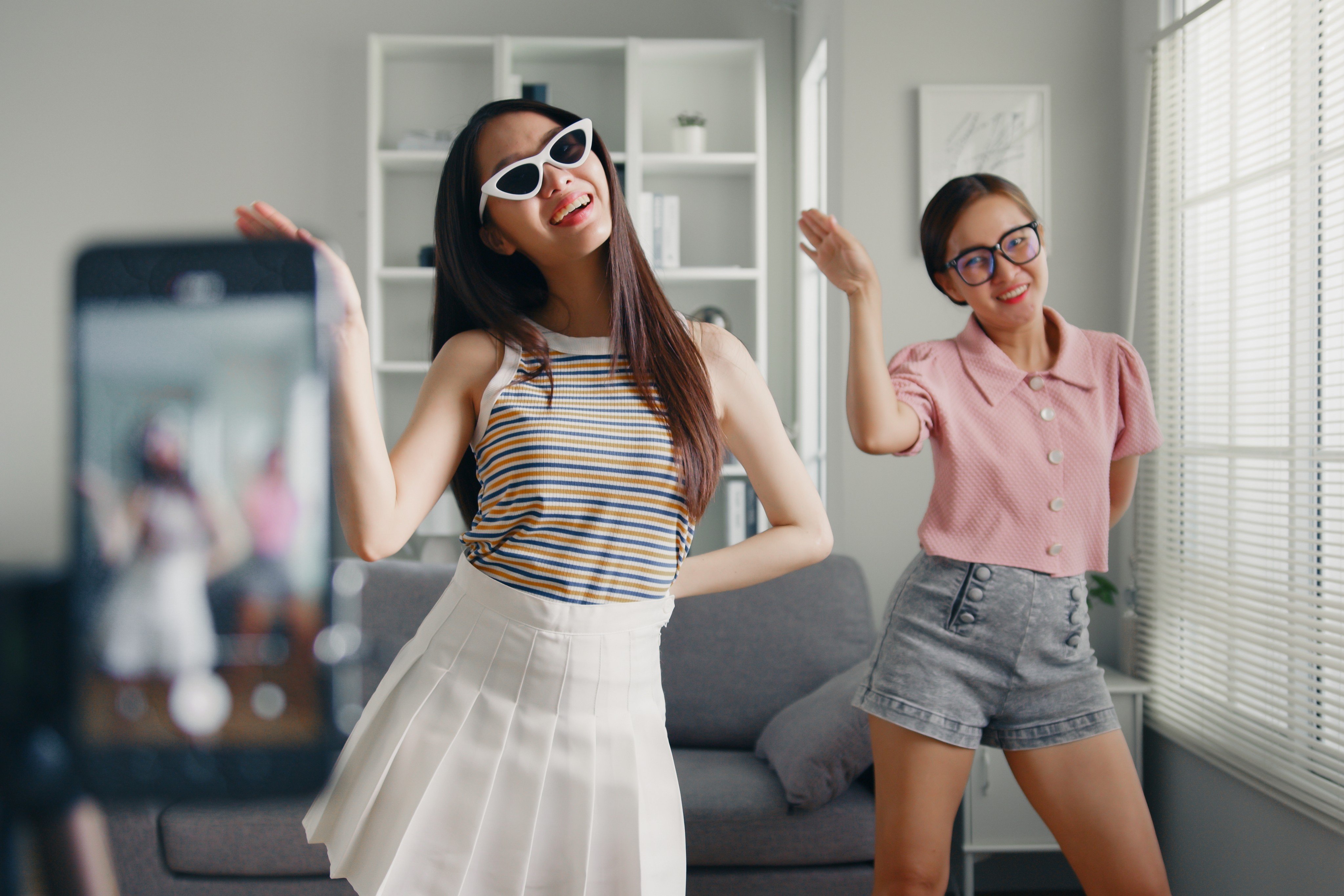 Teens film a TikTok dance video with a smartphone. TikTok challenges and trends are designed to feed an algorithmic popularity contest. Photo: Shutterstock 