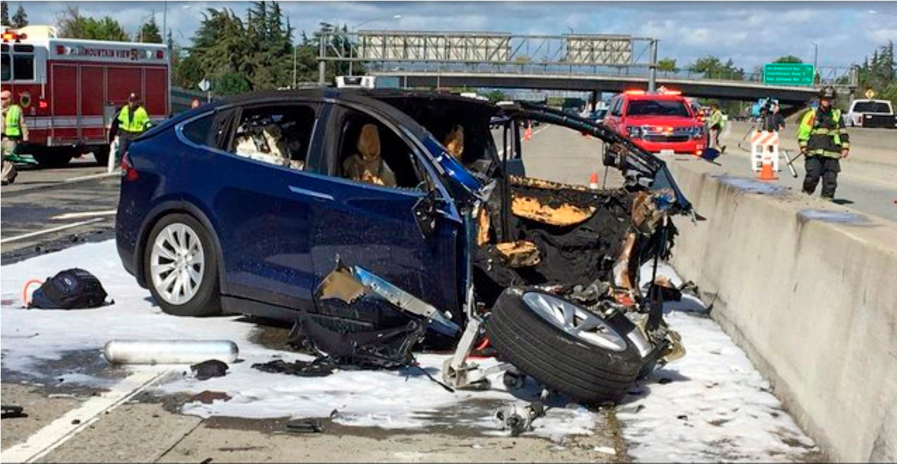 Emergency personnel work at the scene where a Tesla car crashed into a highway barrier in California’s Mountain View in 2018. Photo: KTVU-TV via AP