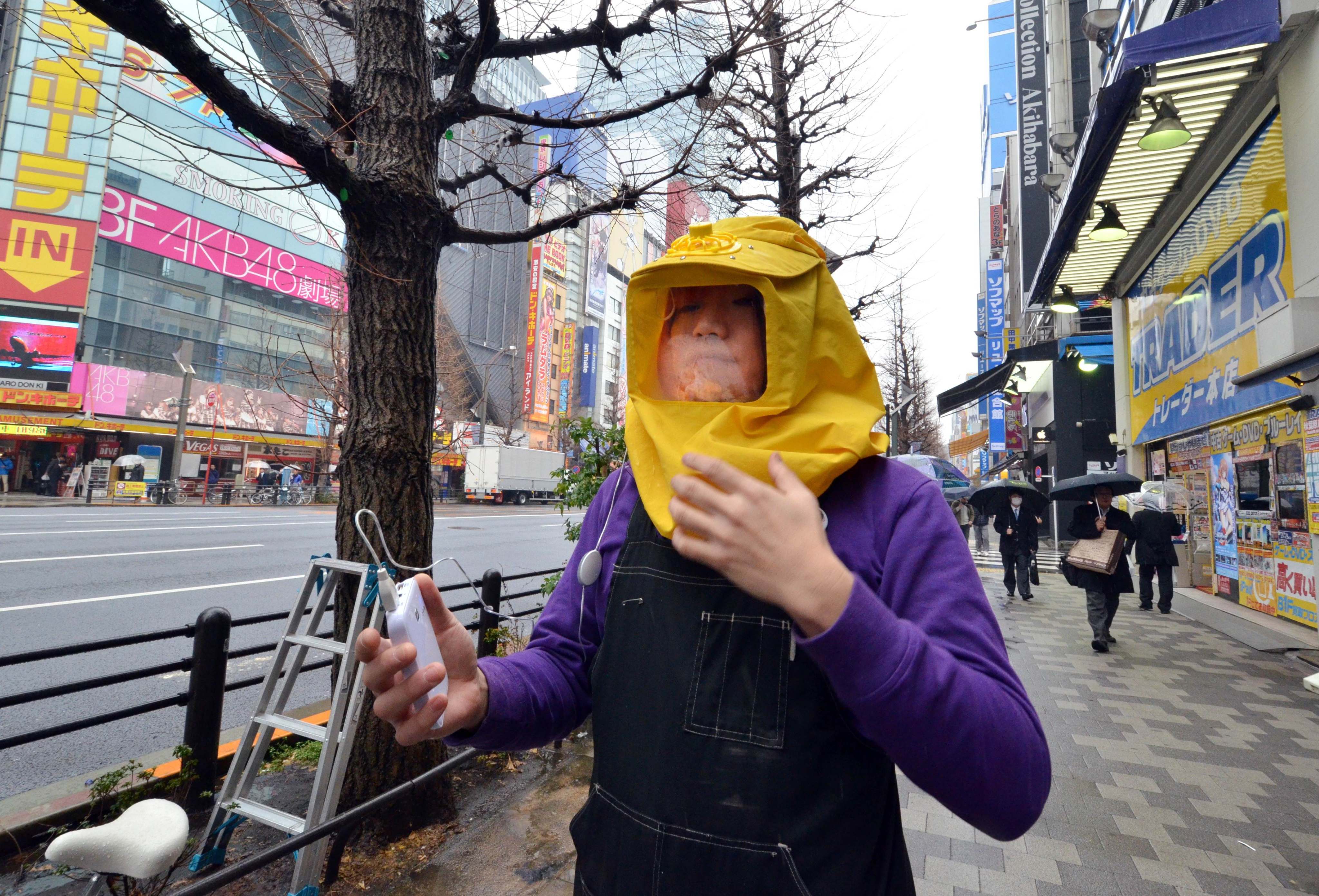 A worker wears a battery-powered pollen protection hood in Tokyo. Photo: AFP 