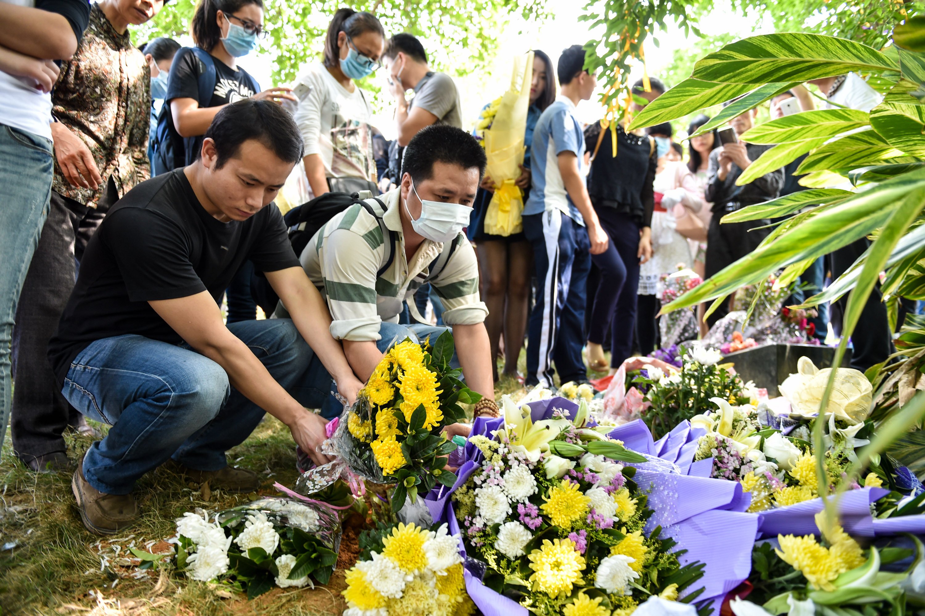 Mourners place the ashes of loved ones next to a tree in an environmentally friendly burial paid for by the Shenzhen government to encourage “green burials”. Photo: Xinhua