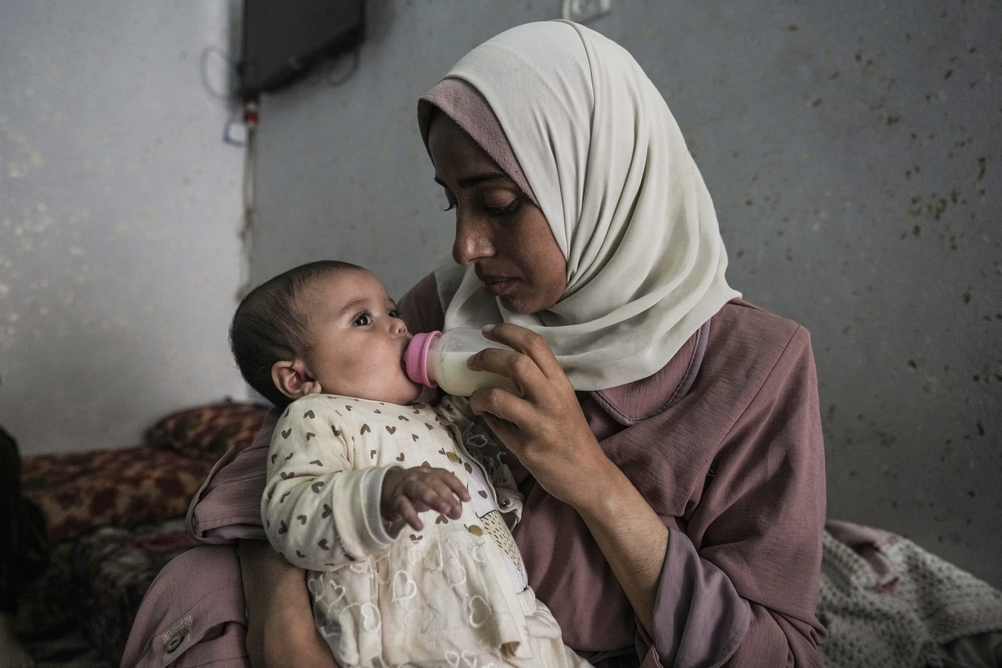 Rola Saqer feeds her baby Masa Mohammad Zaqout in the neighbourhood of Zawaida, central Gaza, on April 4. Photo: AP 

