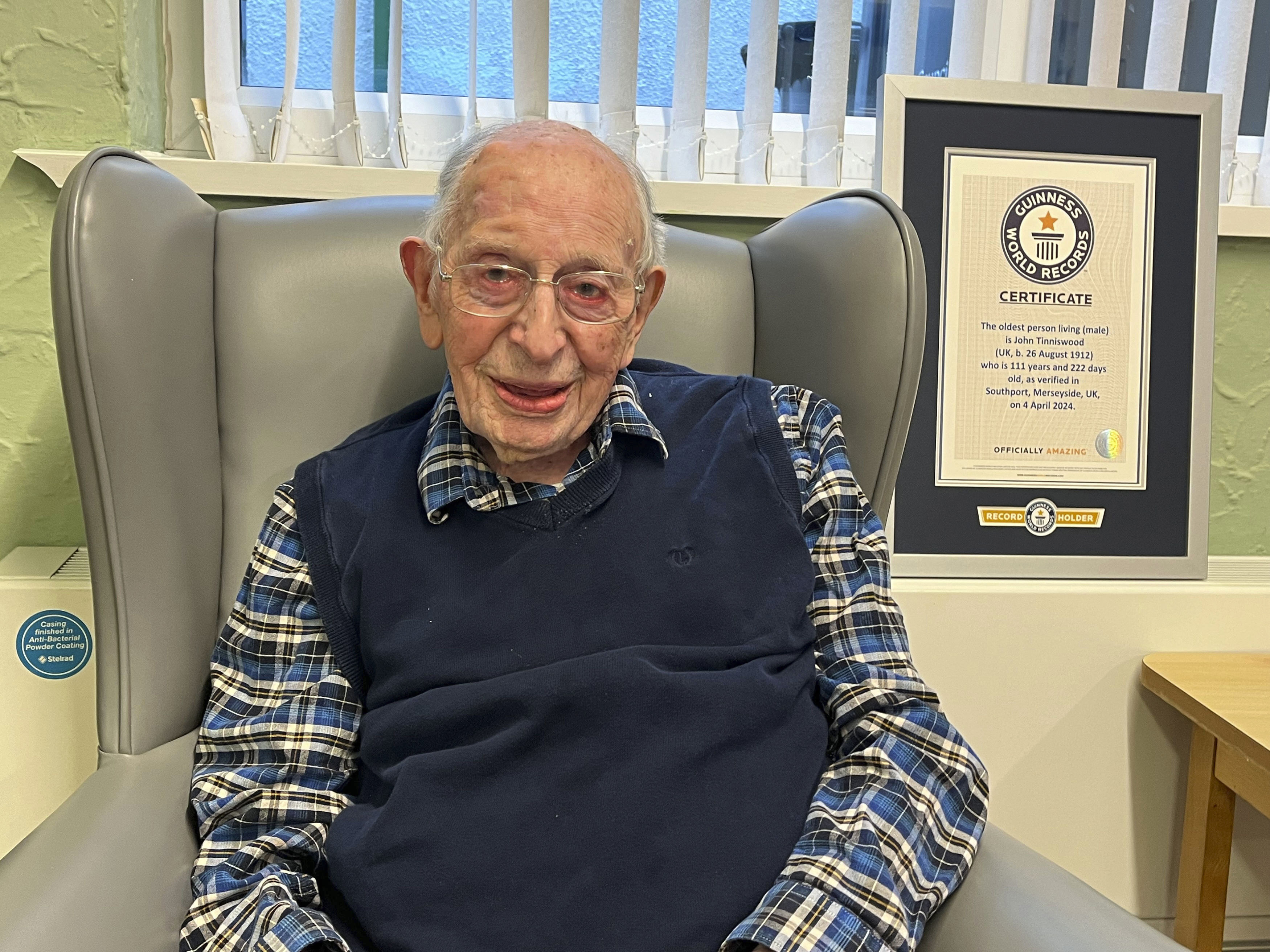 World’s oldest man John Tinniswood, 111, poses with his certificate from Guinness World Records in Southport, Britain, on Thursday. Photo: Guinness World Records via AP