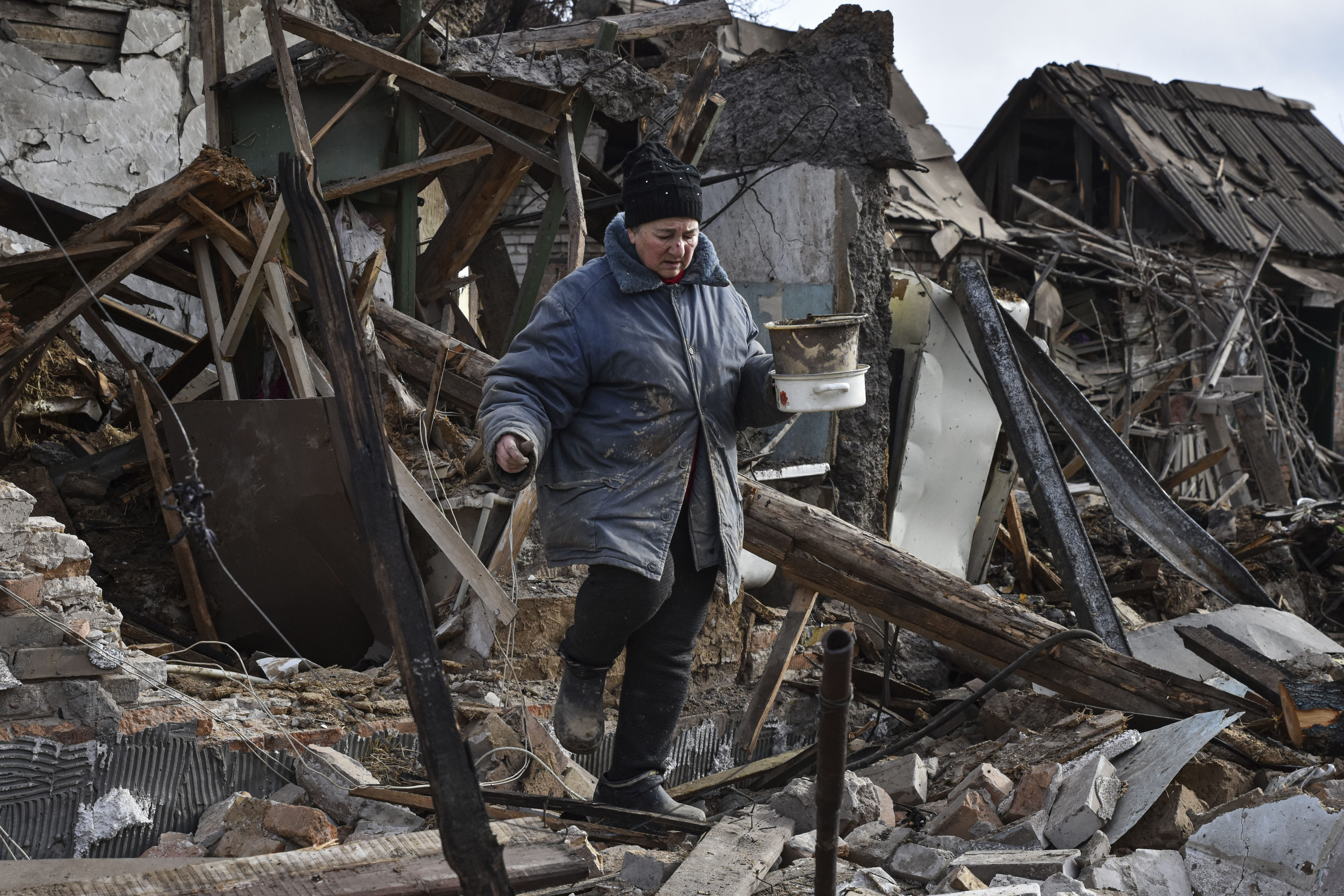 Inna, 71, carries possessions rescued from the rubble of her house which was destroyed by a Russian drone in Zaporizhzhia, Ukraine, in March. Photo: AP