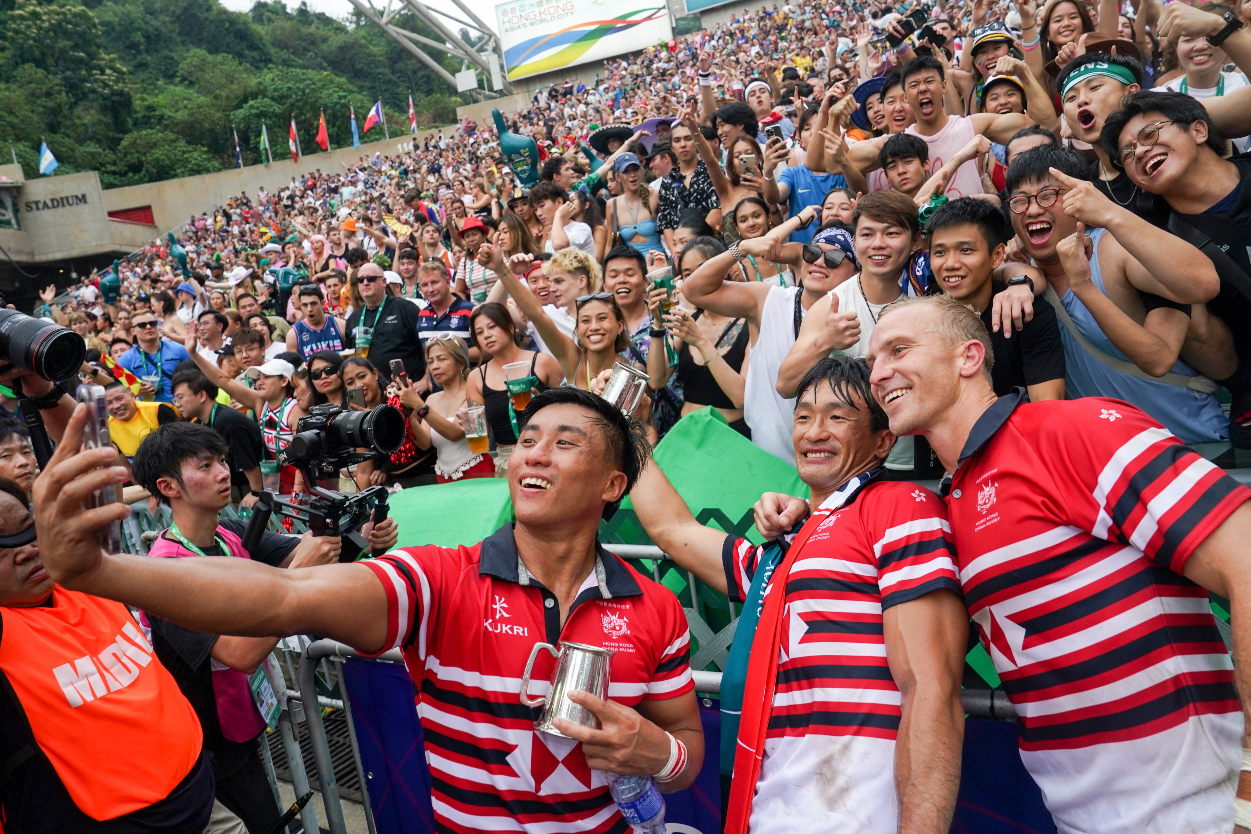 Hong Kong’s Cado Lee, Salom Yiu Kam-shing and Hugo Stiles take a selfie in front of fans in the South Stand after beating Japan. Photo: Elson Li