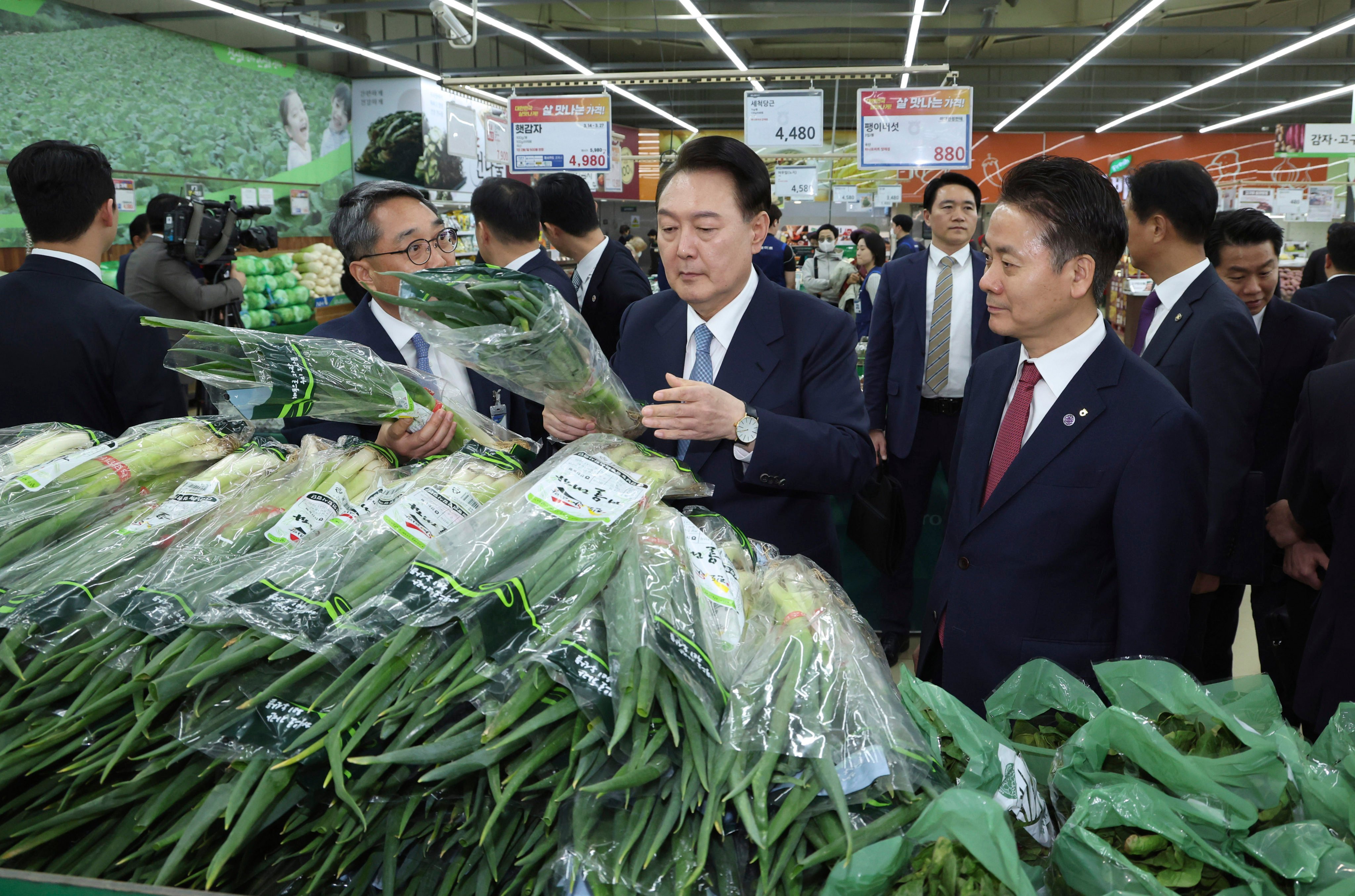 South Korean President Yoon Suk-yeol (centre) checks the price of spring onions at a supermarket in Seoul on March 18. Photo: Yonhap via AP